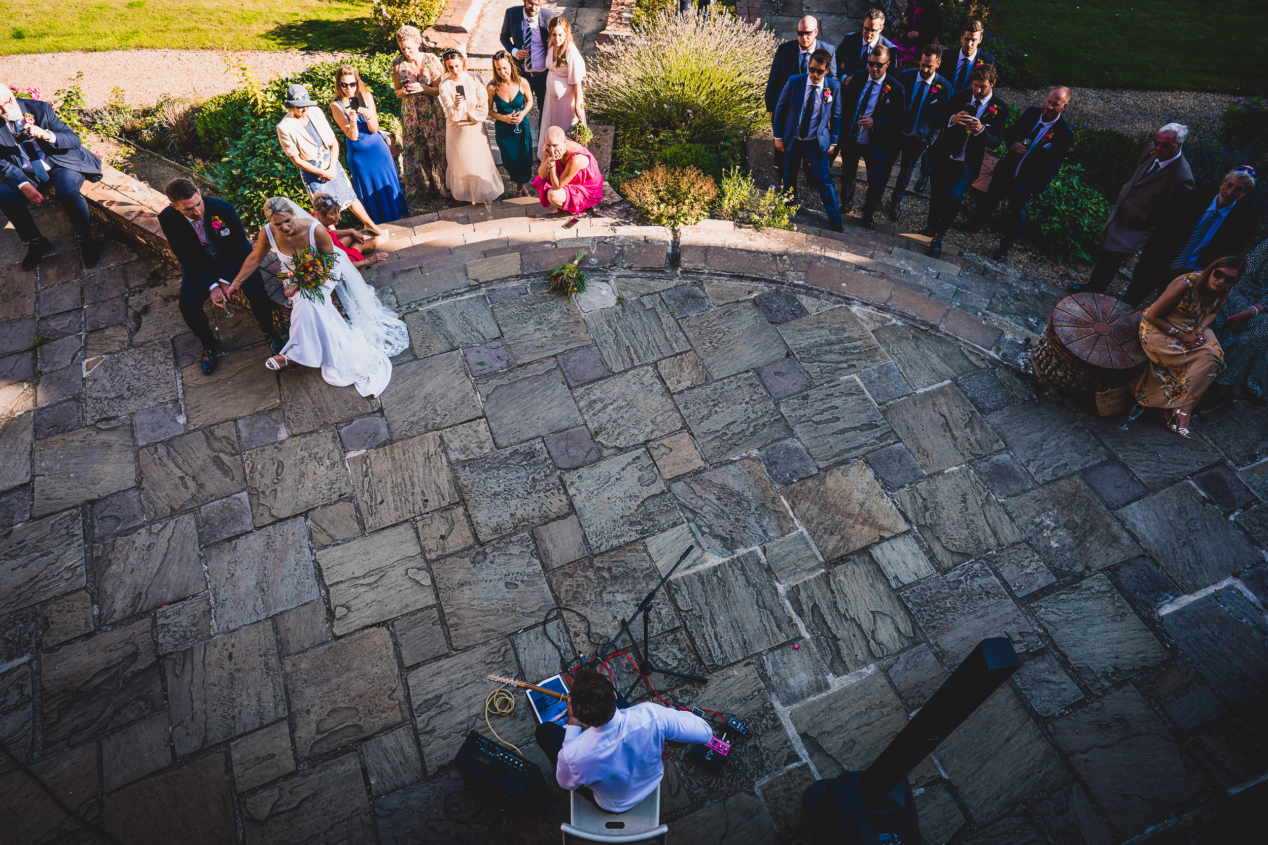 A wedding photographer capturing a groom and bride surrounded by a crowd.