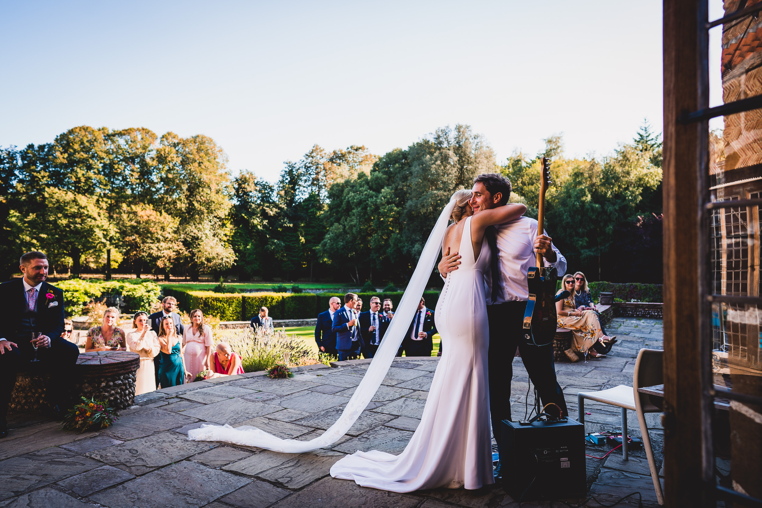 A groom and bride passionately kiss at their wedding reception.