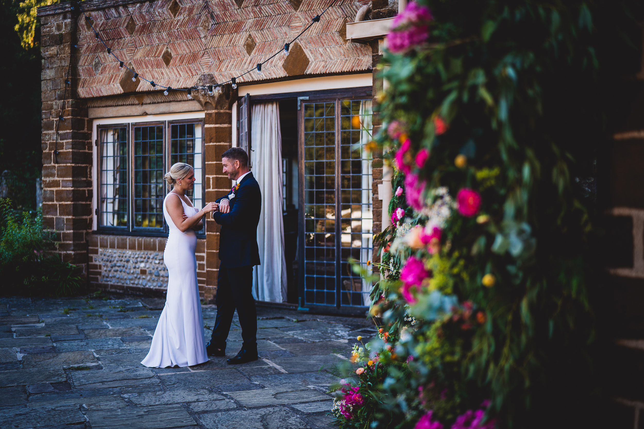 A wedding photo of a bride and groom standing in front of a brick building.