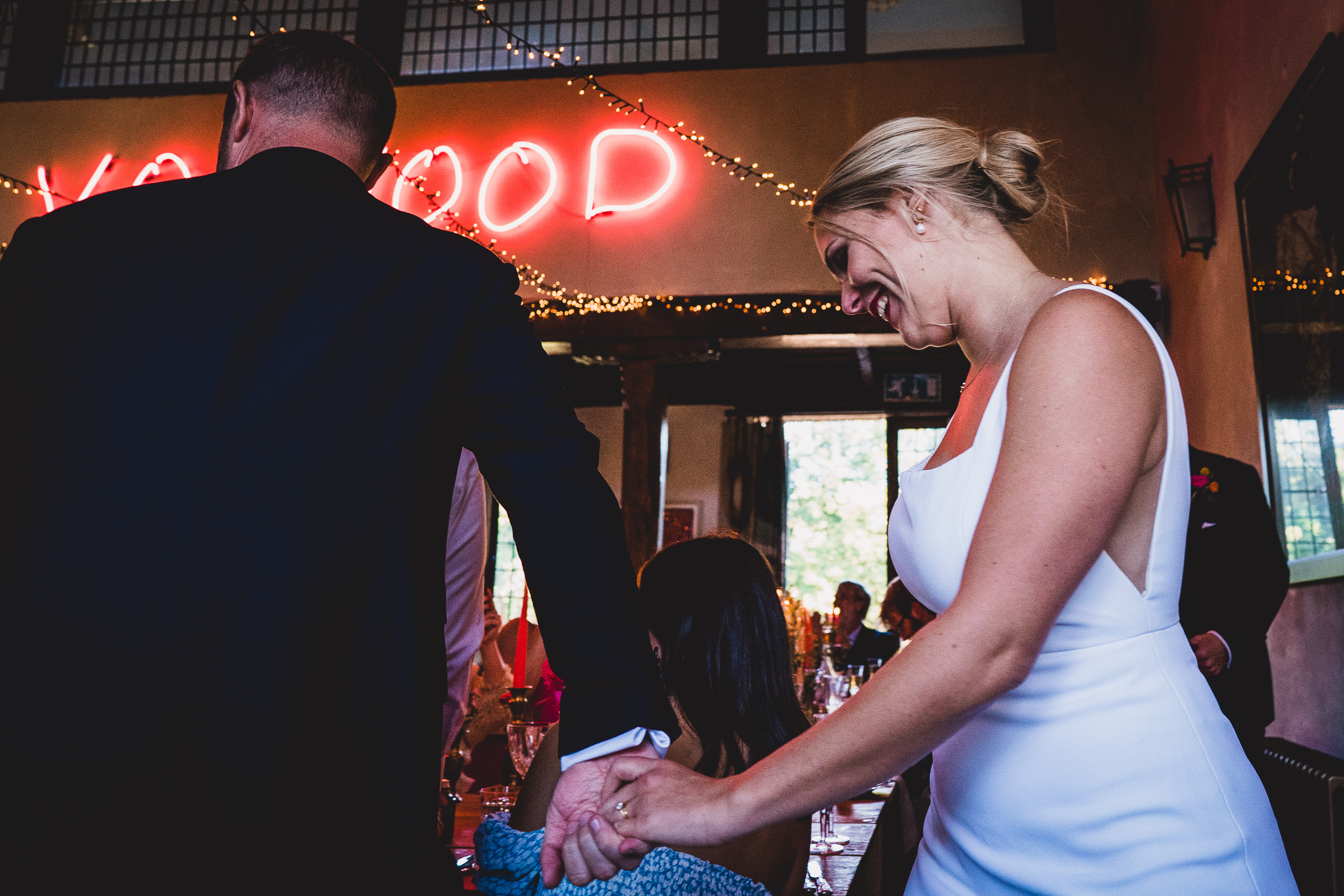 A wedding photographer captures a bride and groom holding hands in a cherished wedding photo.