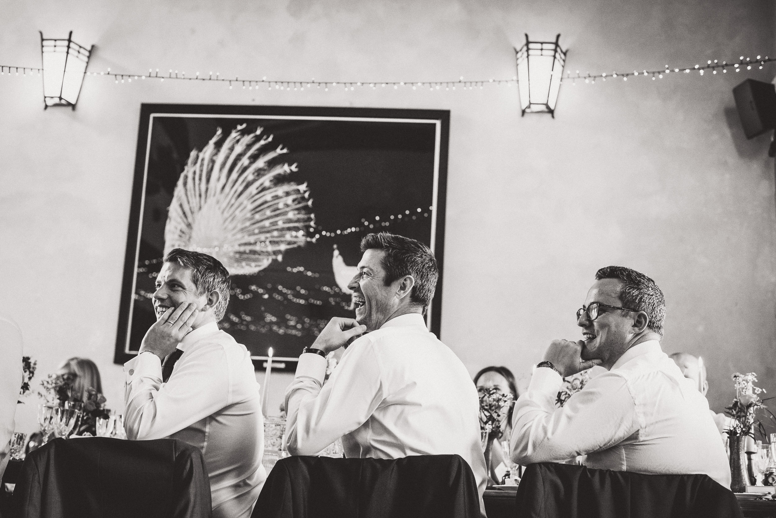 A black and white photo of a group of men at a wedding table.