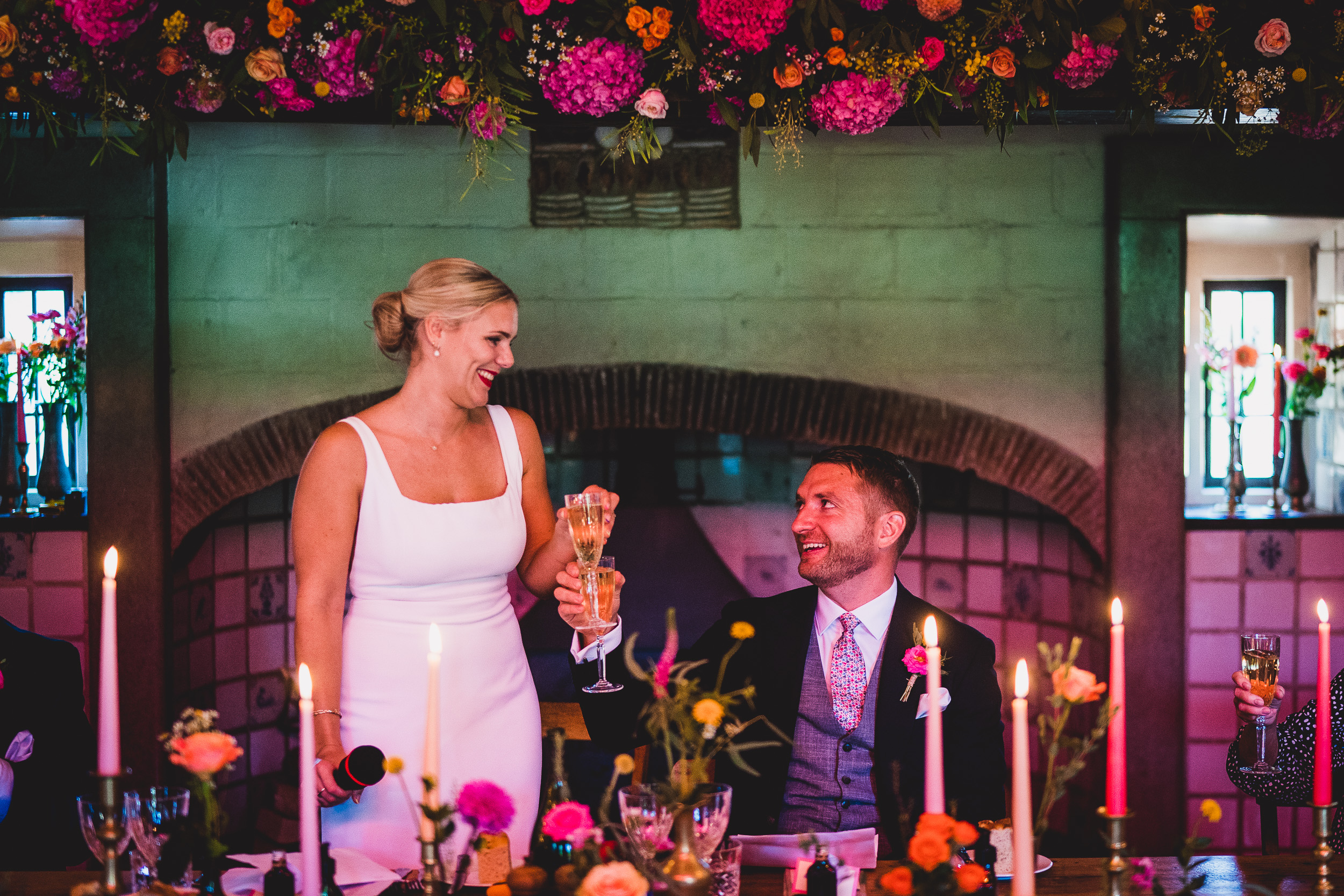 A wedding photo capturing the bride and groom toasting champagne at their reception.