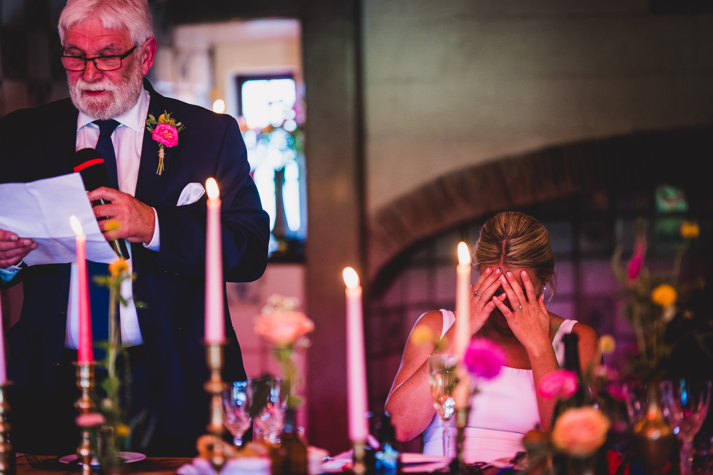 A wedding photographer capturing a man's speech.