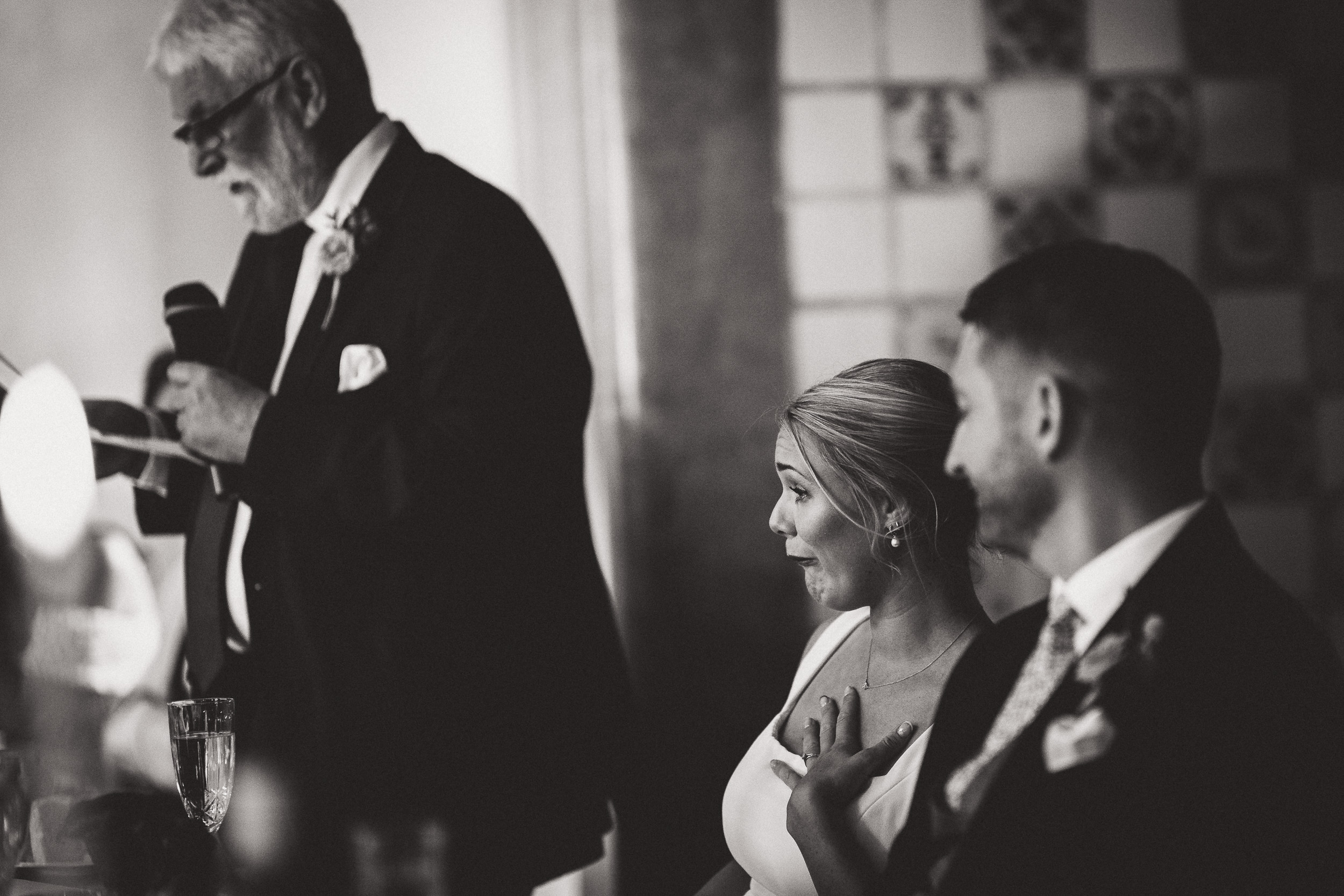 A photographer captures the moment as the groom delivers a heartfelt speech at the wedding.