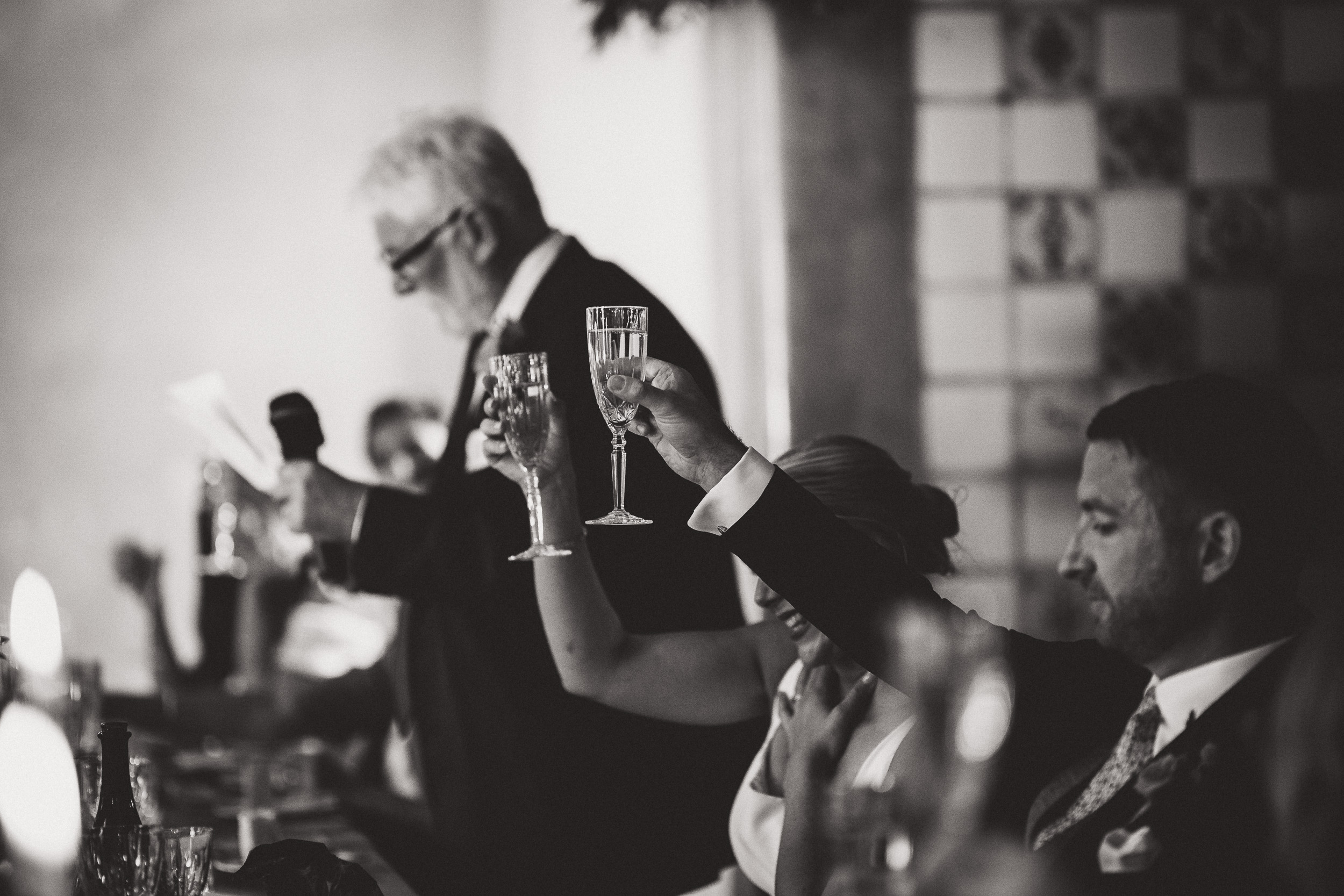 A wedding couple toasting glasses in a wedding photo.