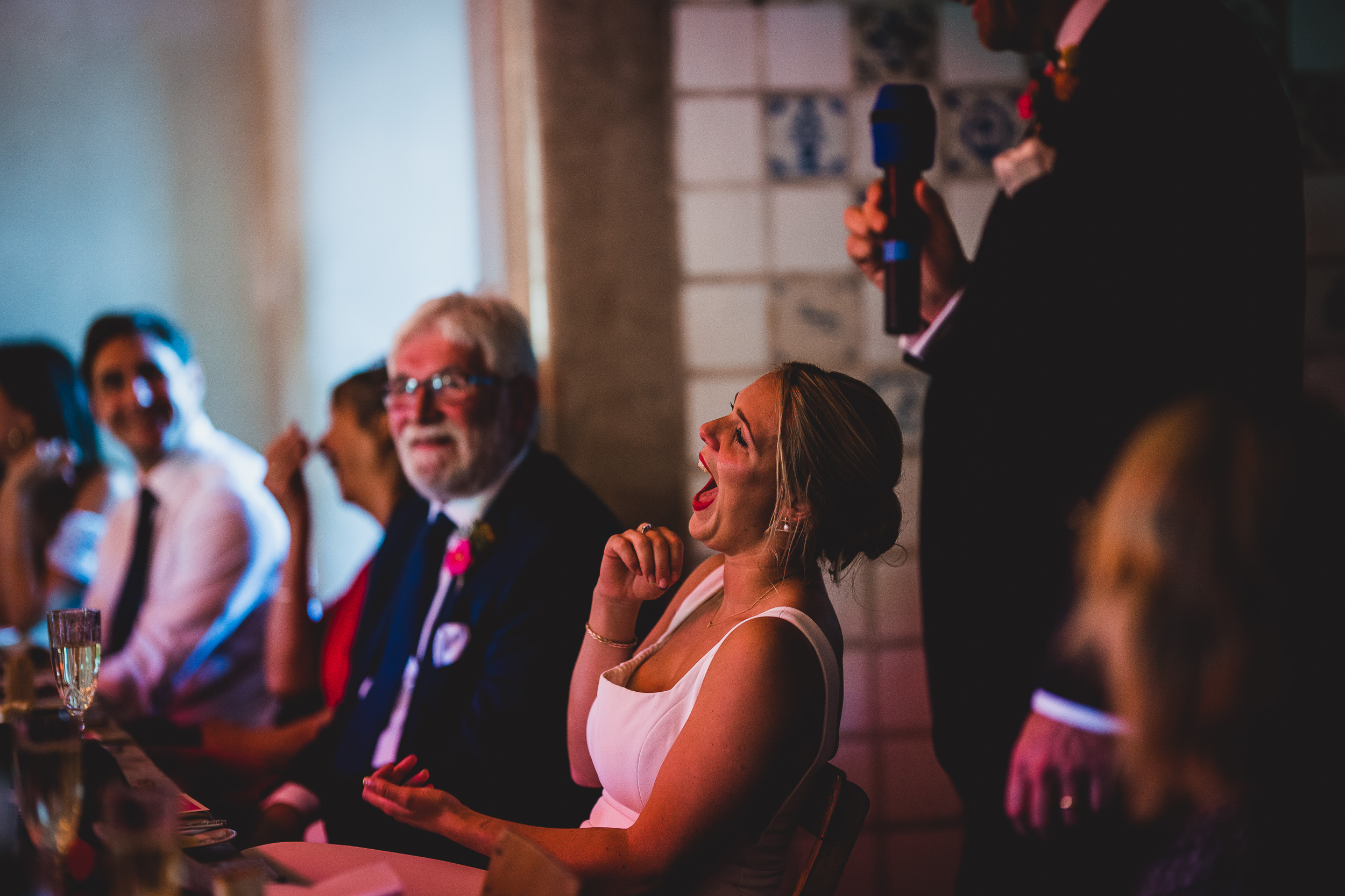 A groom and wedding photographer capture laughter at the reception.