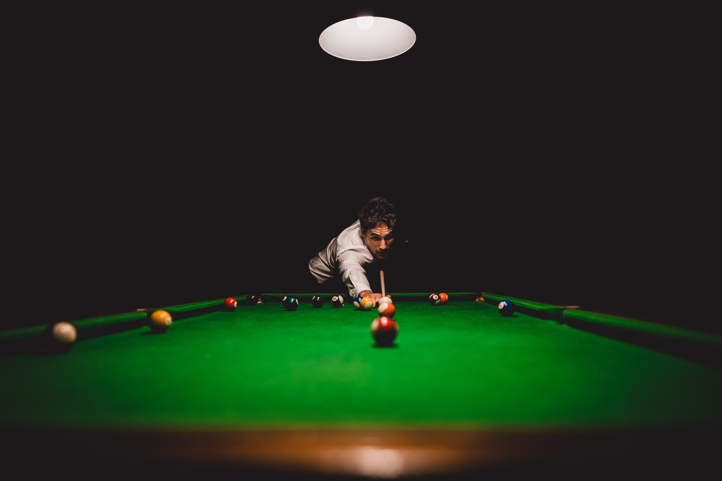 A wedding photographer capturing a snooker game during a wedding.