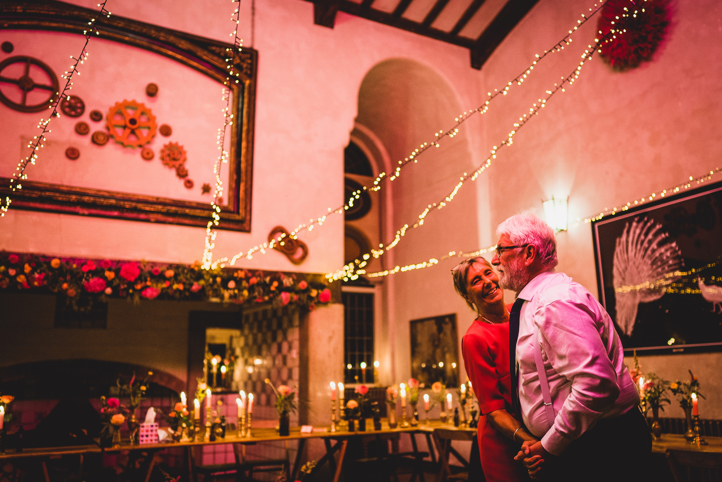 A bride and groom standing in a beautifully lit room, capturing a wedding photo.