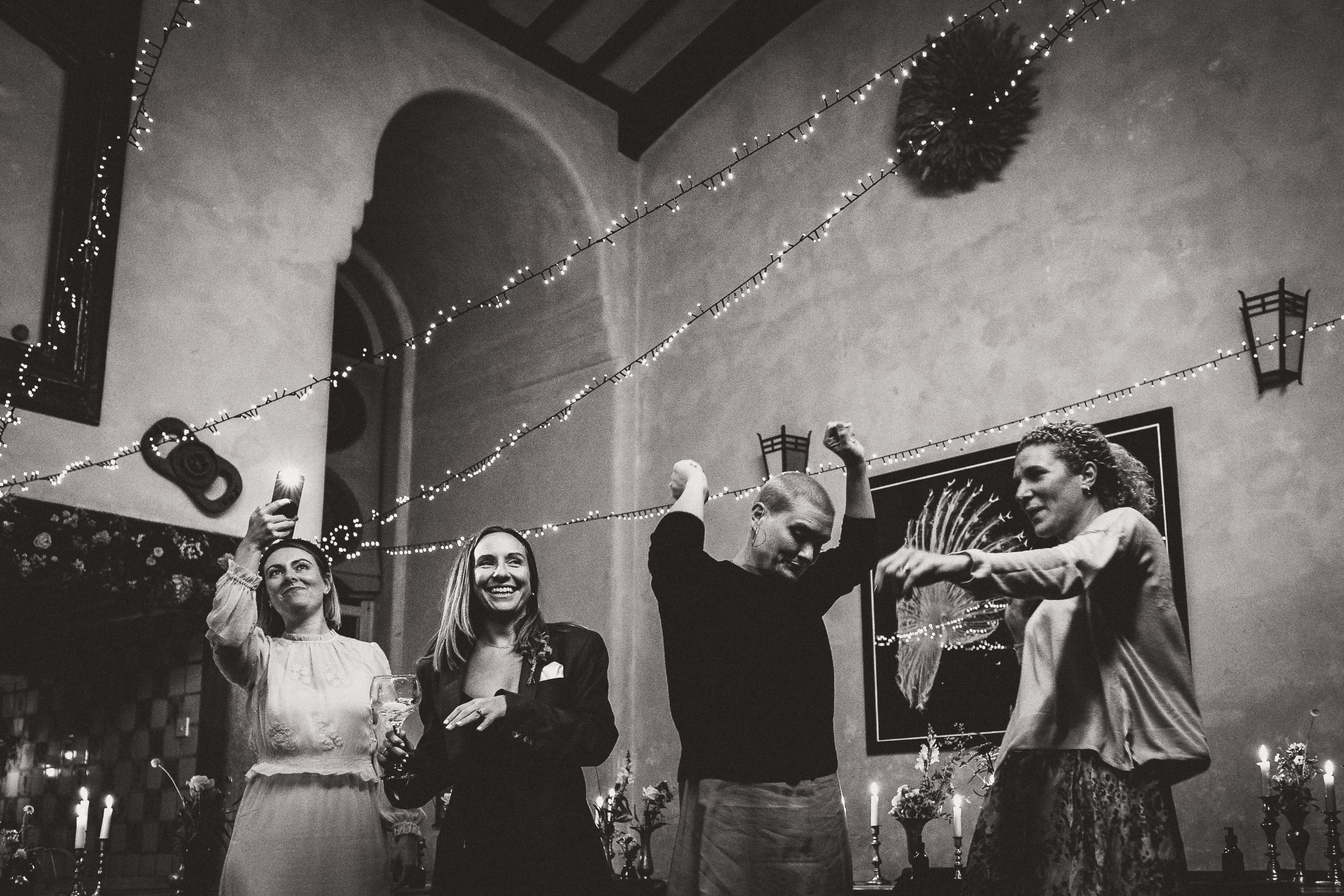 A wedding photo featuring a bride and a group of people dancing in a room.