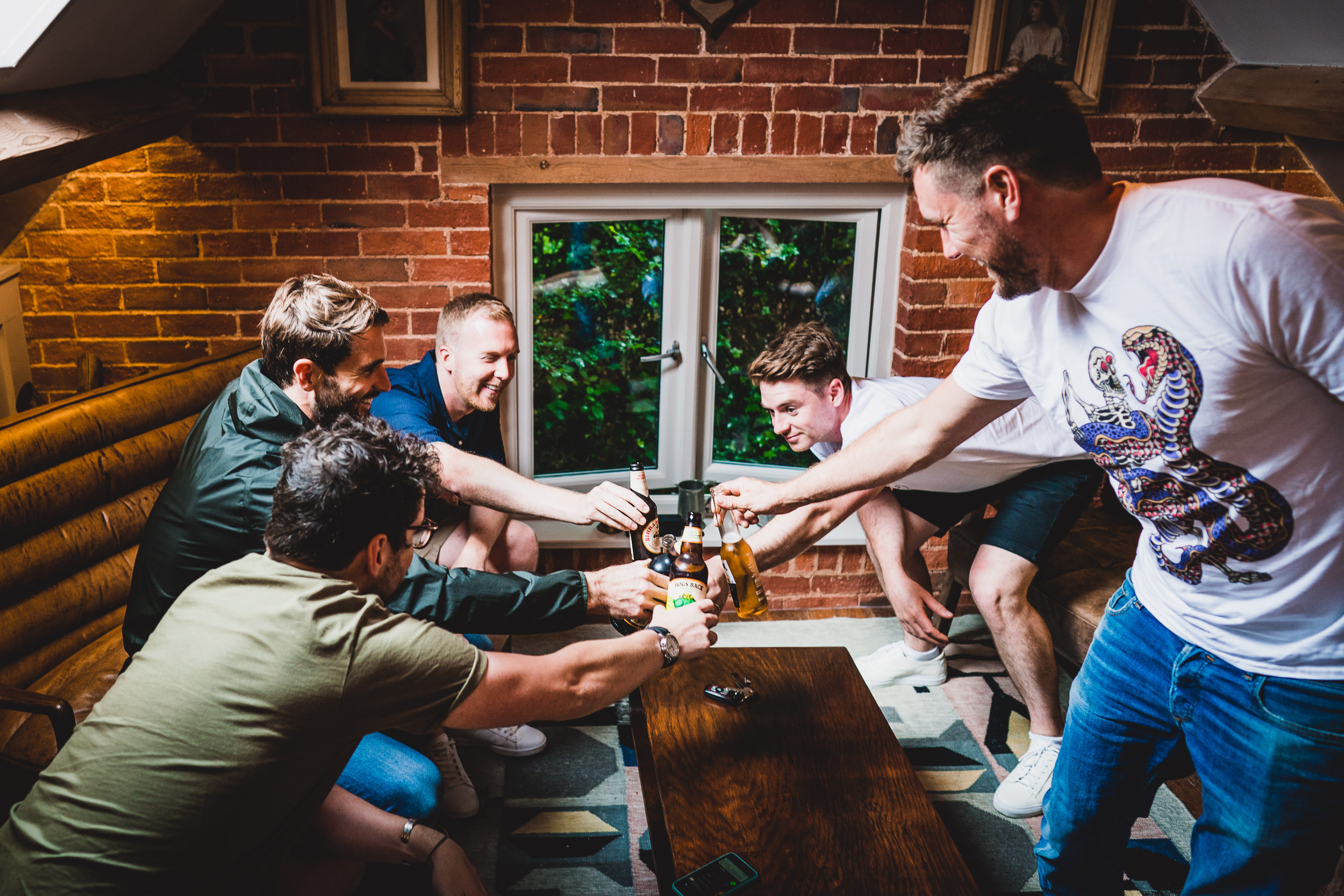 A group of men toasting beer at a wedding reception.