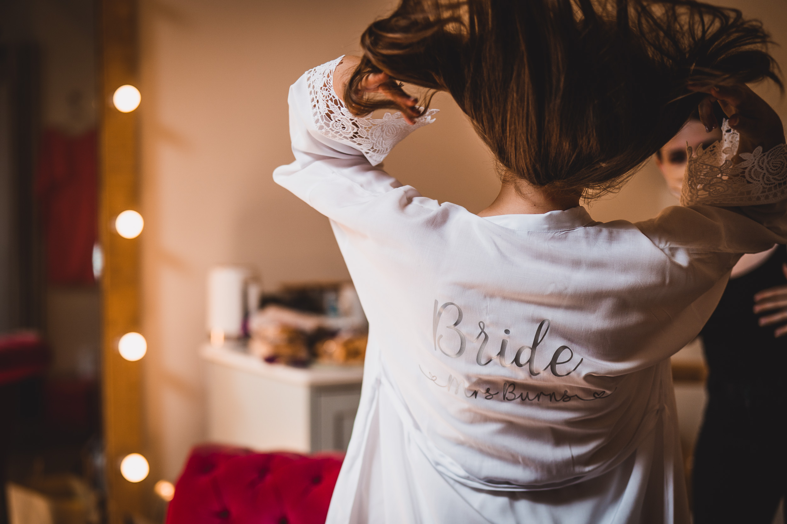 A bride preparing for her wedding in a robe, captured by a wedding photographer.