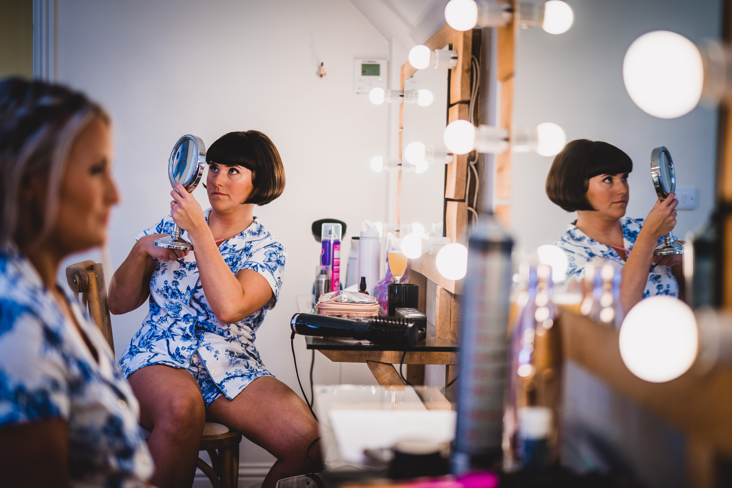 A bride is getting ready in front of a mirror.