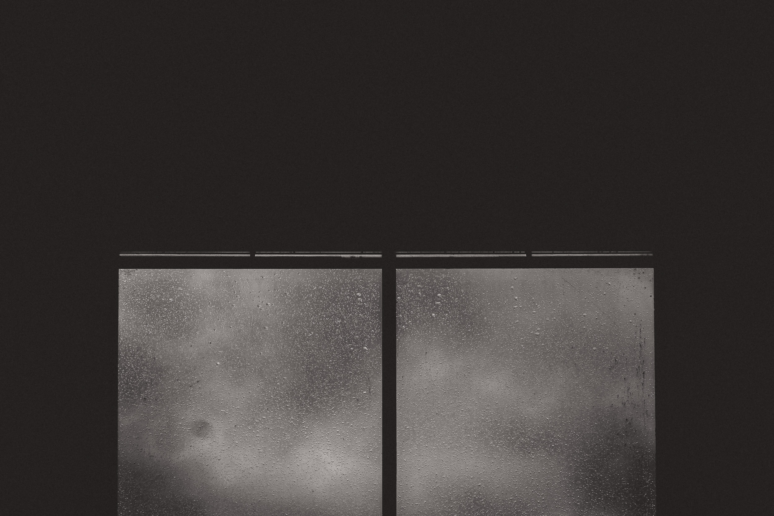 A rainy window captured in black and white.