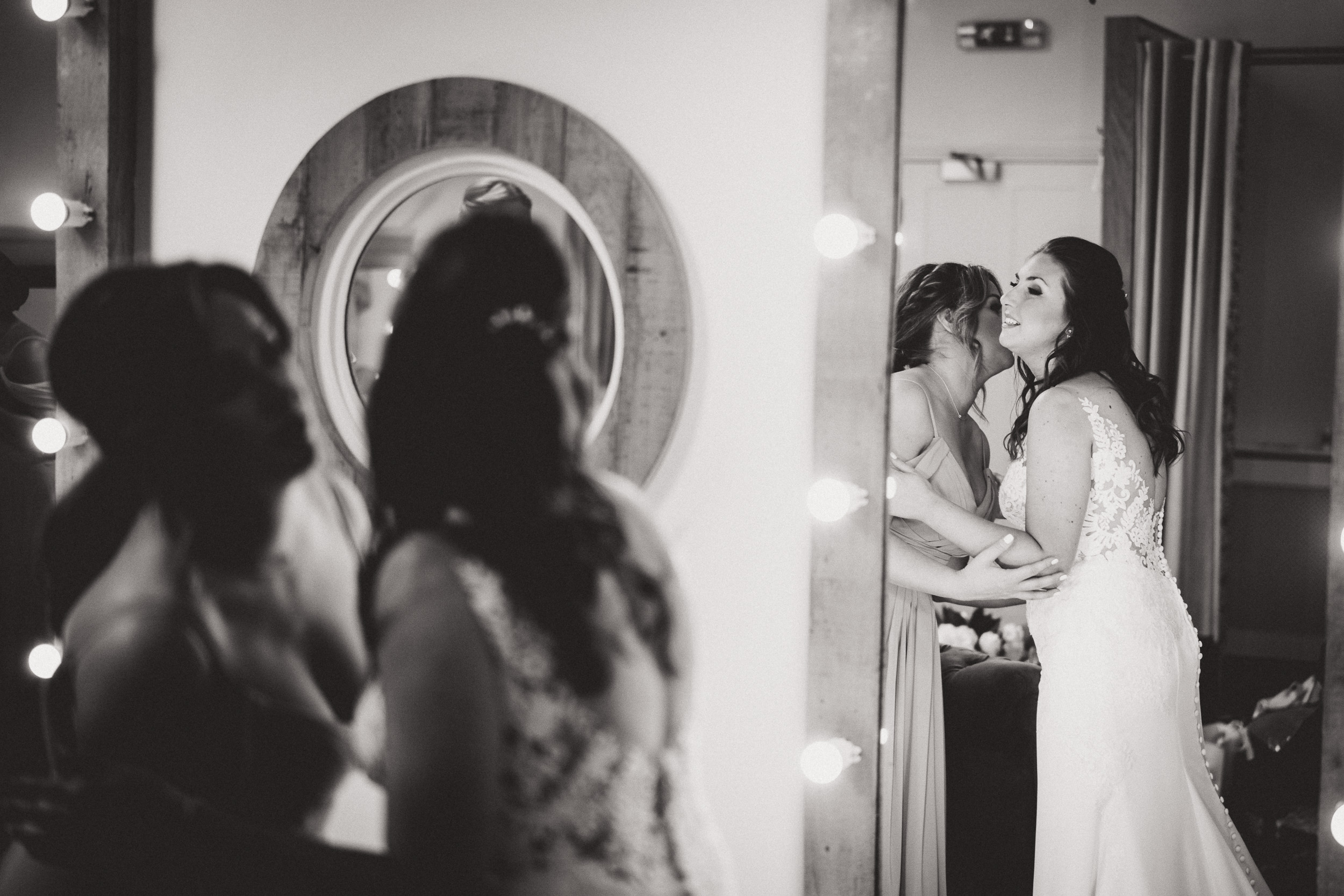 A bride is preparing for her special day in front of a mirror.