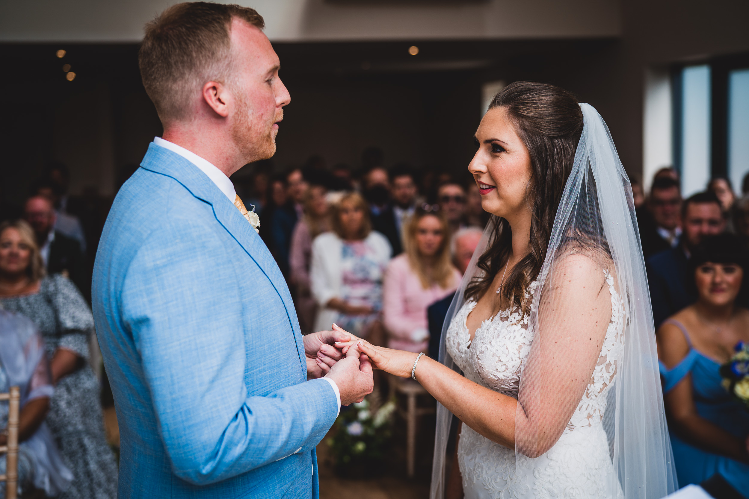 A groom exchanging vows with his bride in a wedding ceremony (wedding, groom).