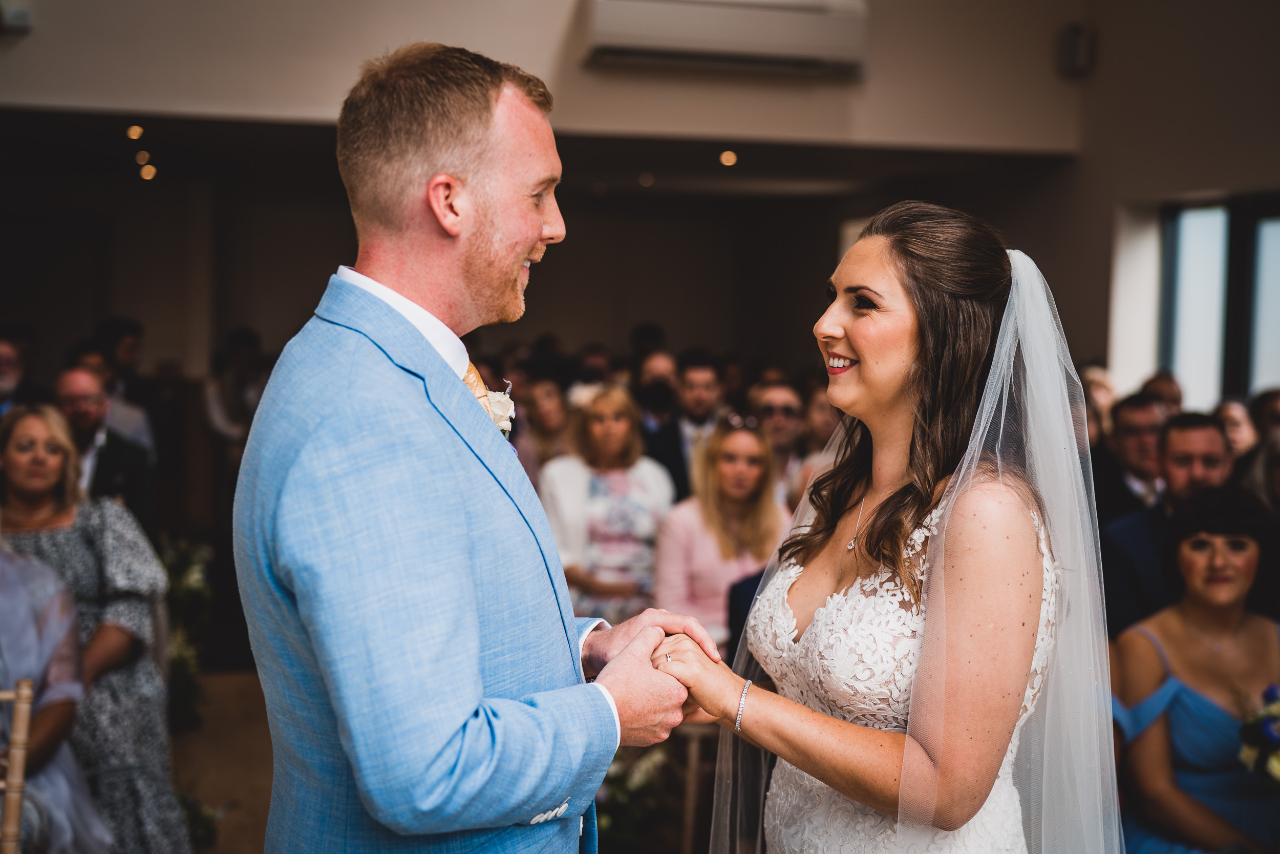 A bride and groom exchange vows in a wedding photo captured by their wedding photographer.