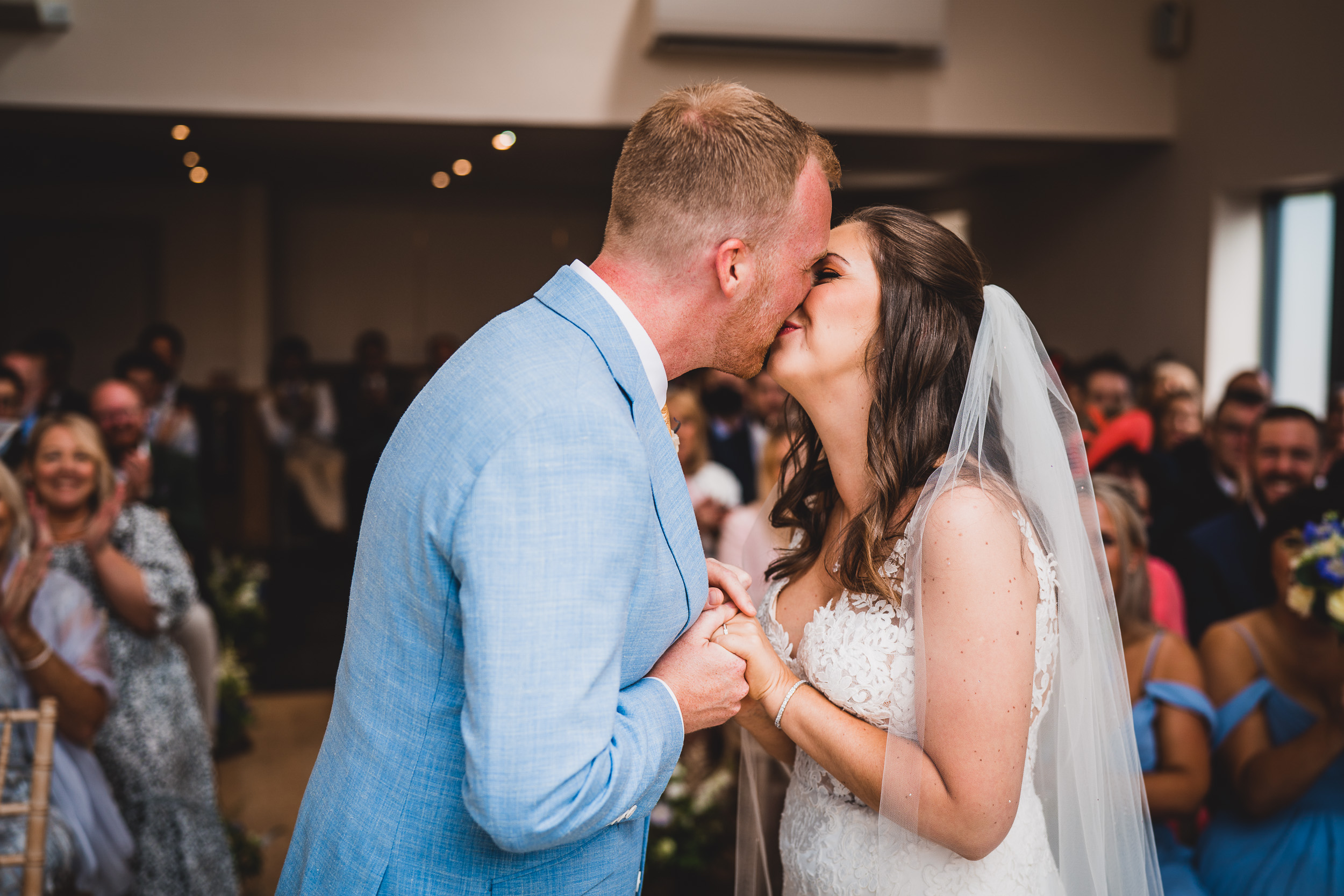 A groom kisses the bride during their wedding ceremony.