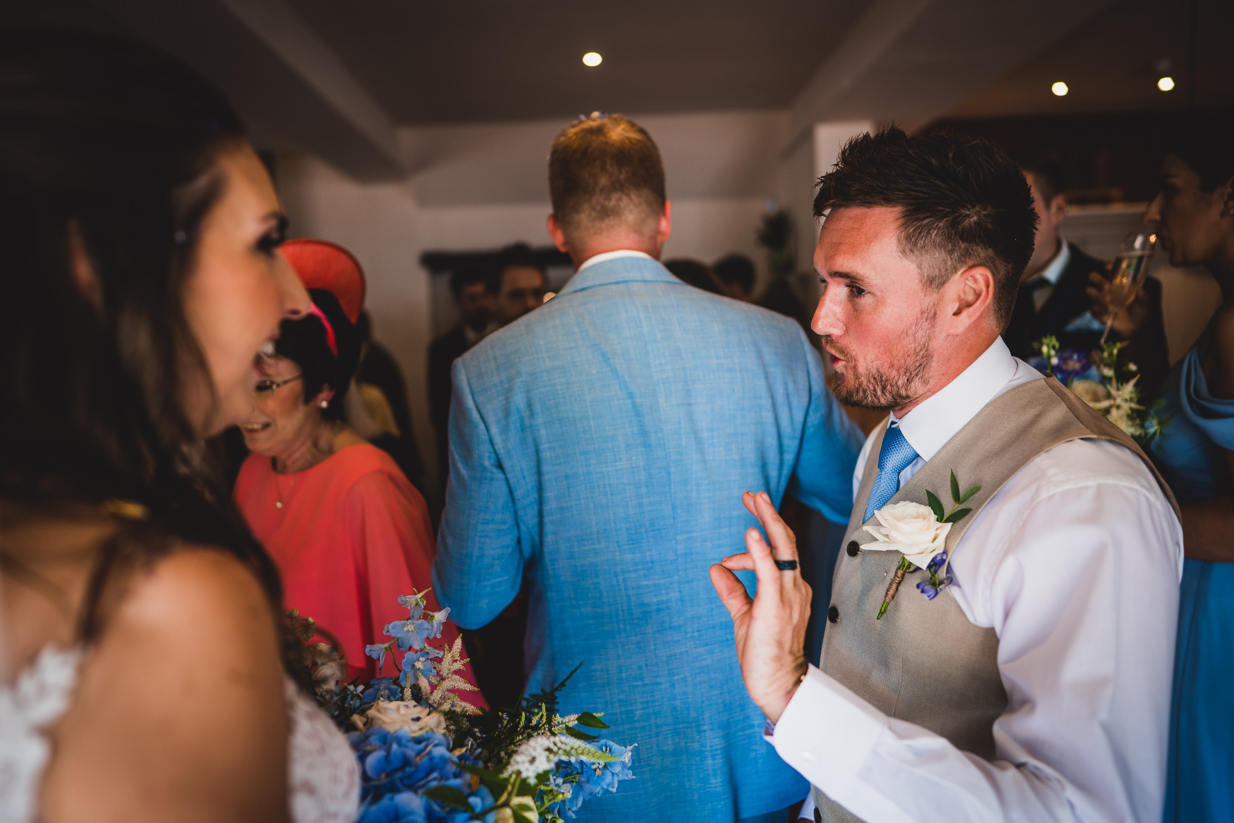 A groom and bride conversing during their wedding reception.