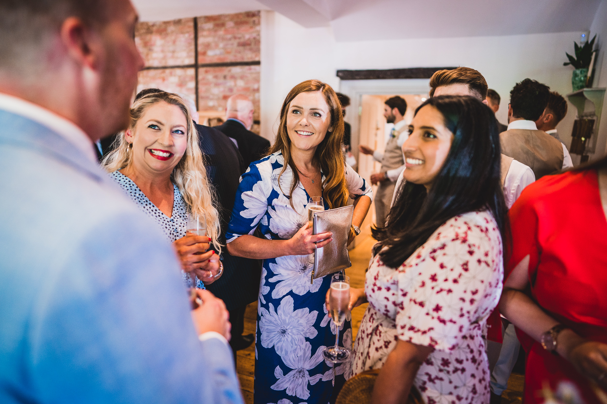 A group of people talking at a wedding party.