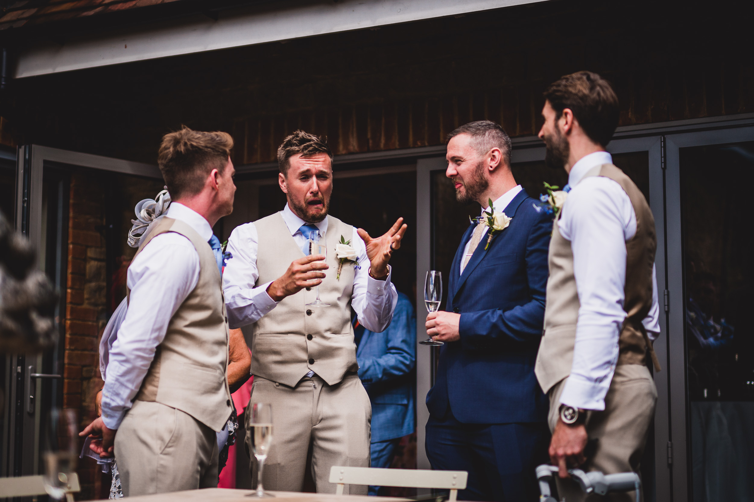 A group of groomsmen conversing at a wedding.