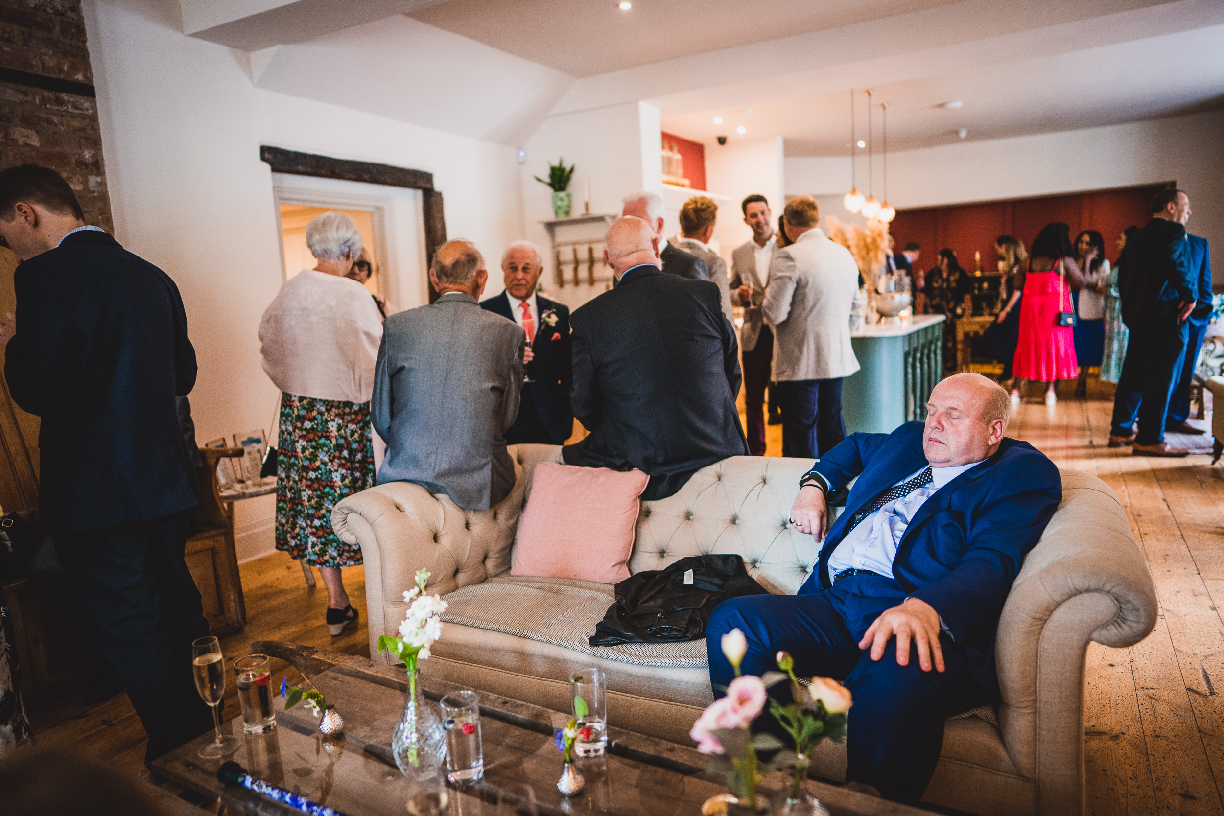 A groom sitting on a couch in a room.