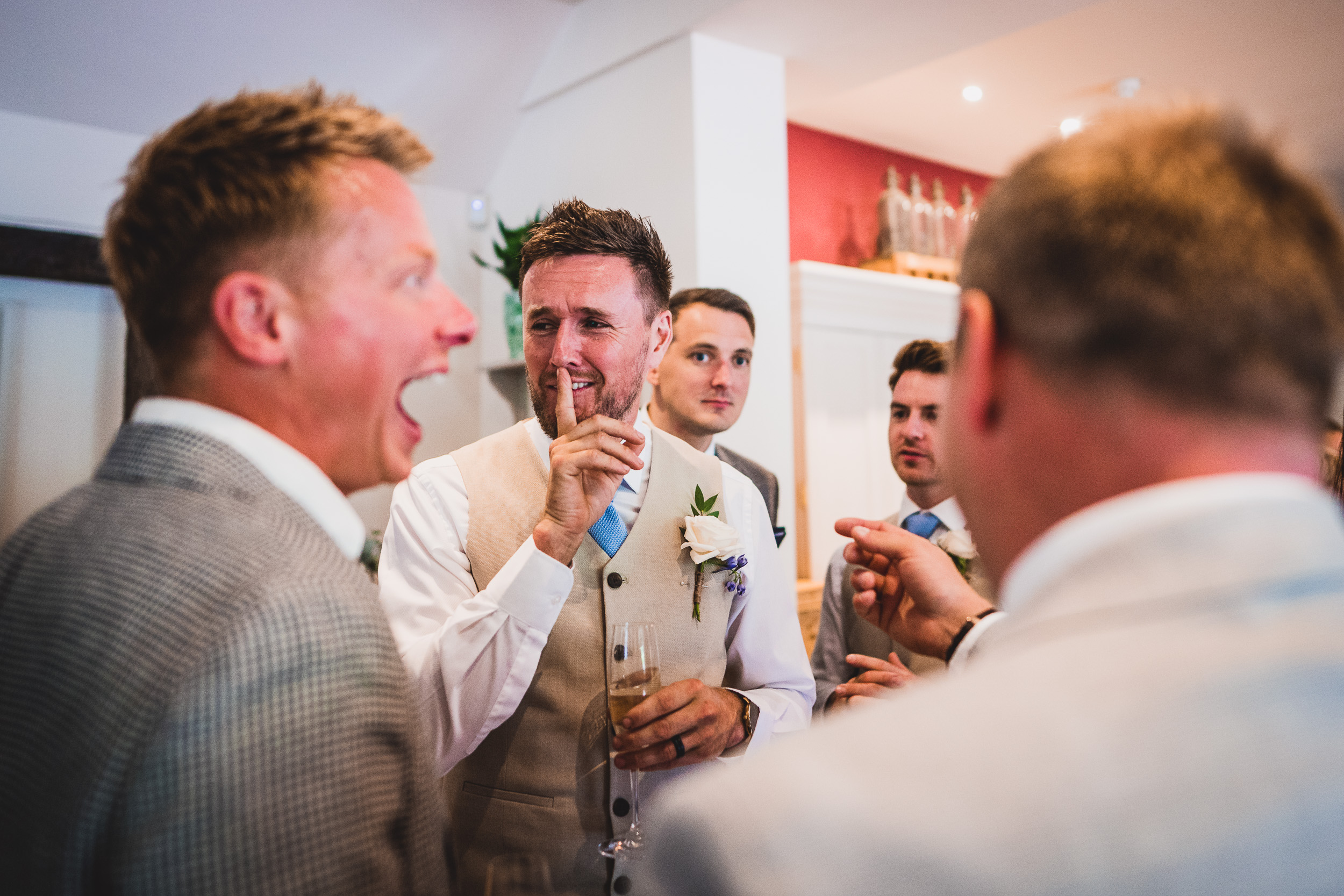 A group of groomsmen conversing at a wedding.