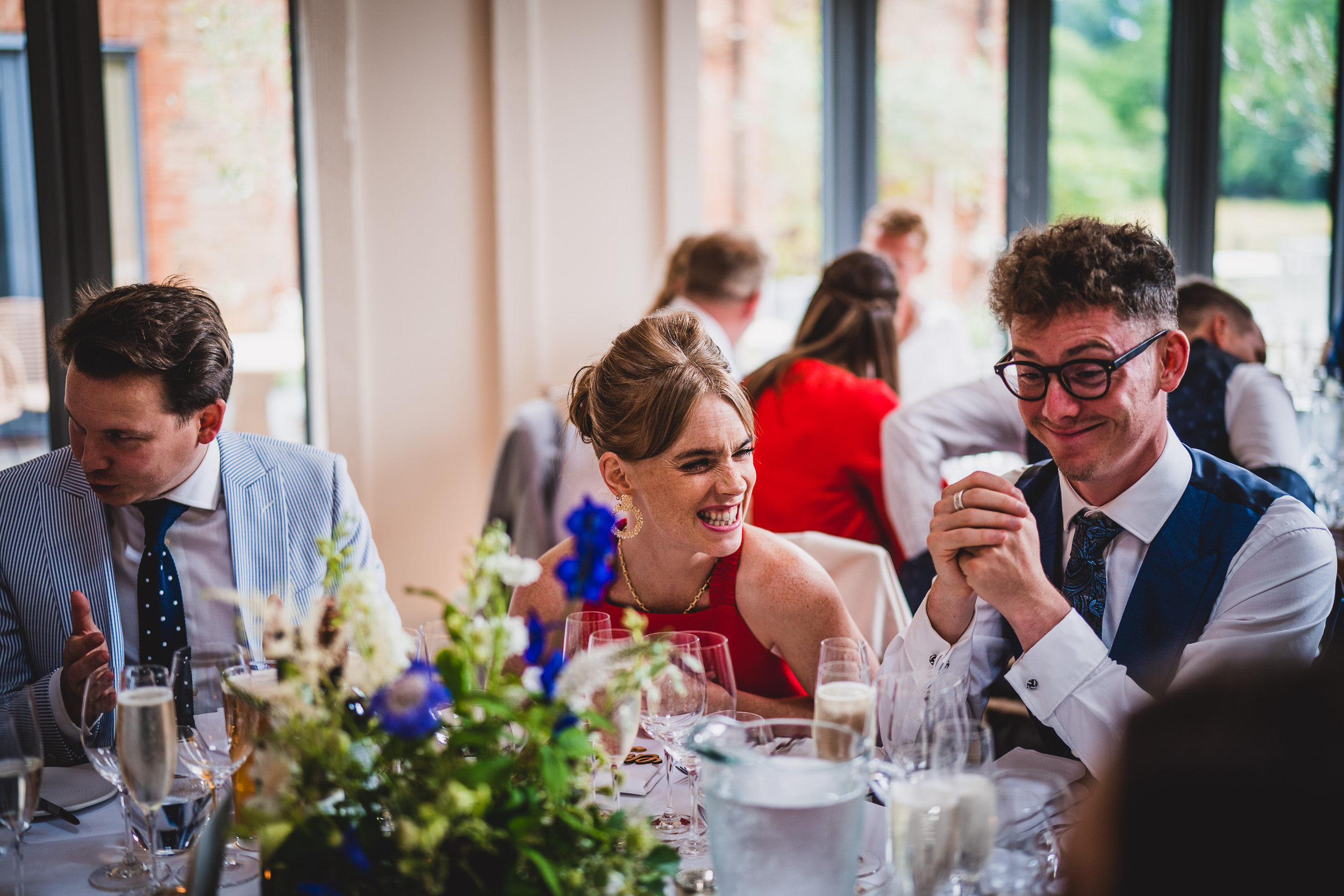 A wedding couple sharing joyful laughter at their reception.