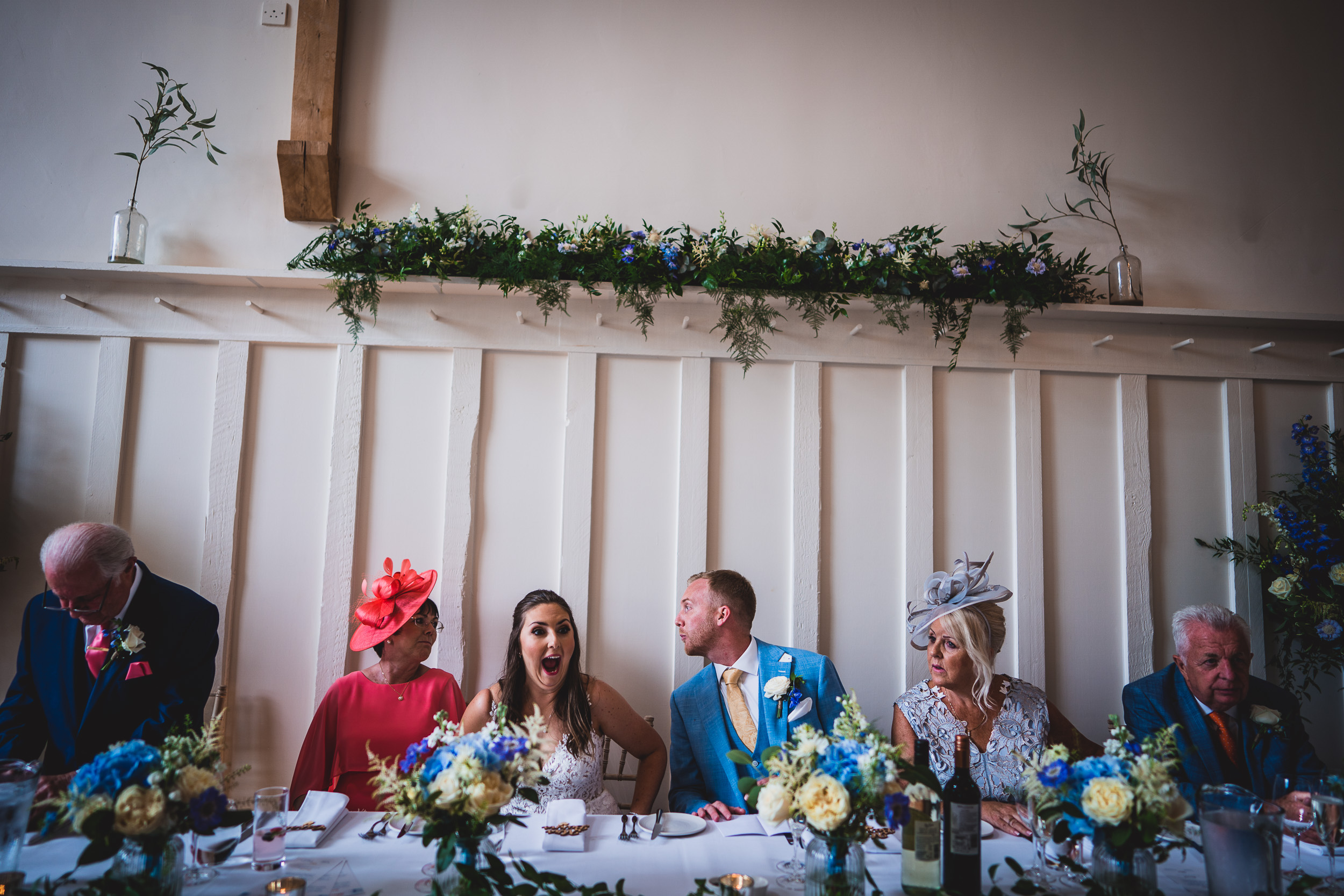 A group of people sitting around a wedding photo at a table.