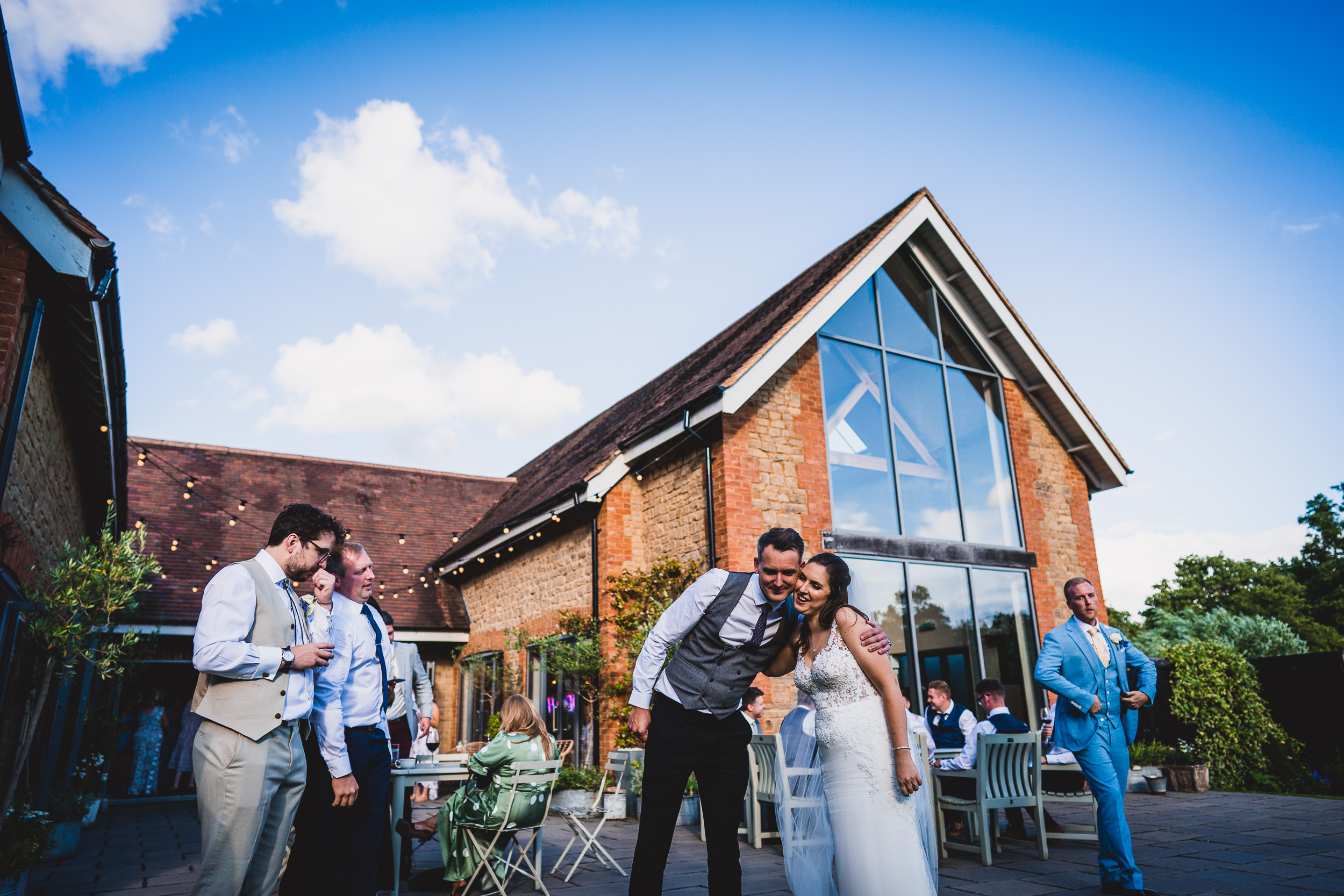 A bride and groom posing for their wedding photo in front of a building captured by a wedding photographer.