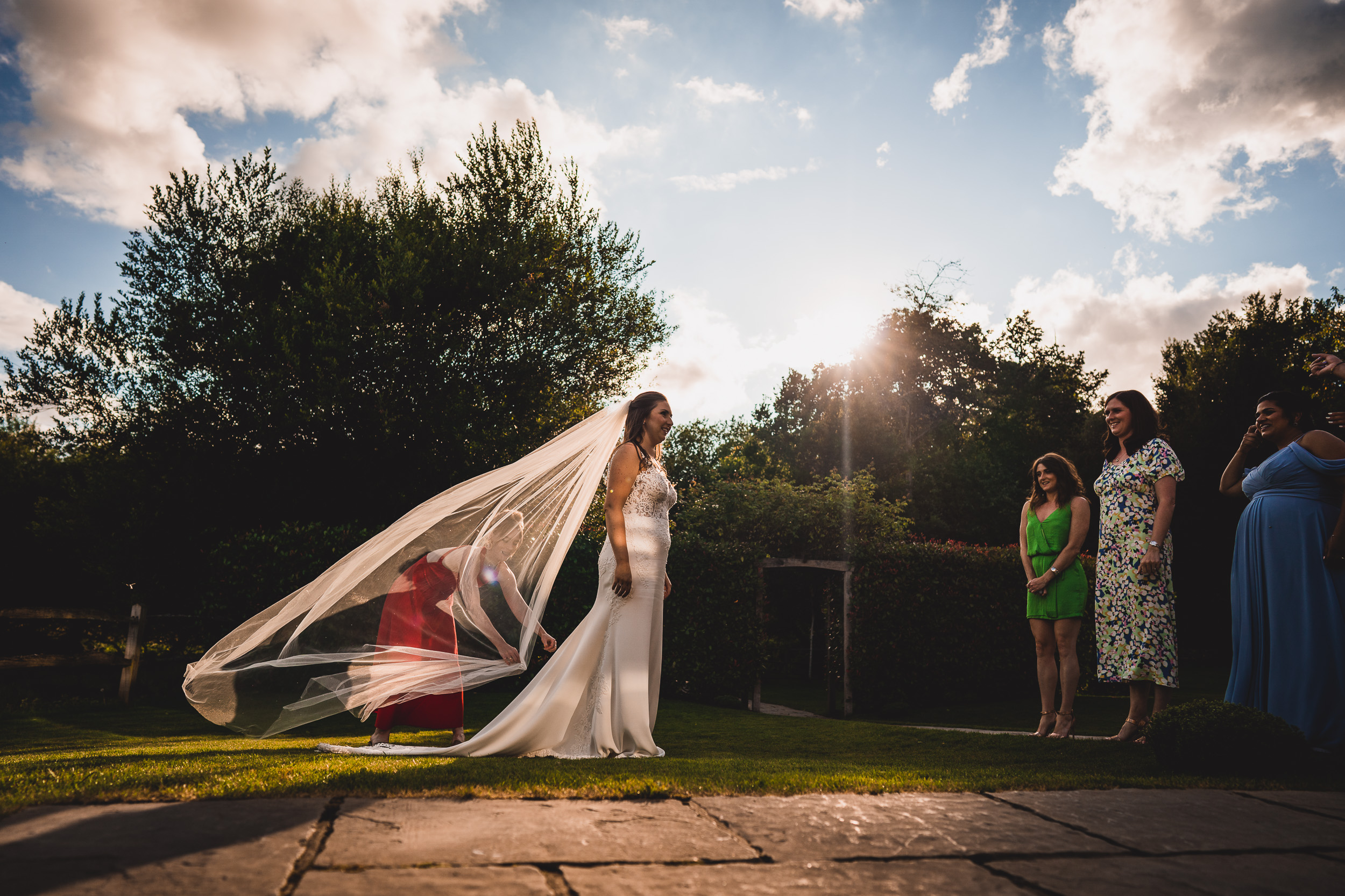 A bride and groom captured in a beautiful wedding photo with the bride's veil blowing in the wind.