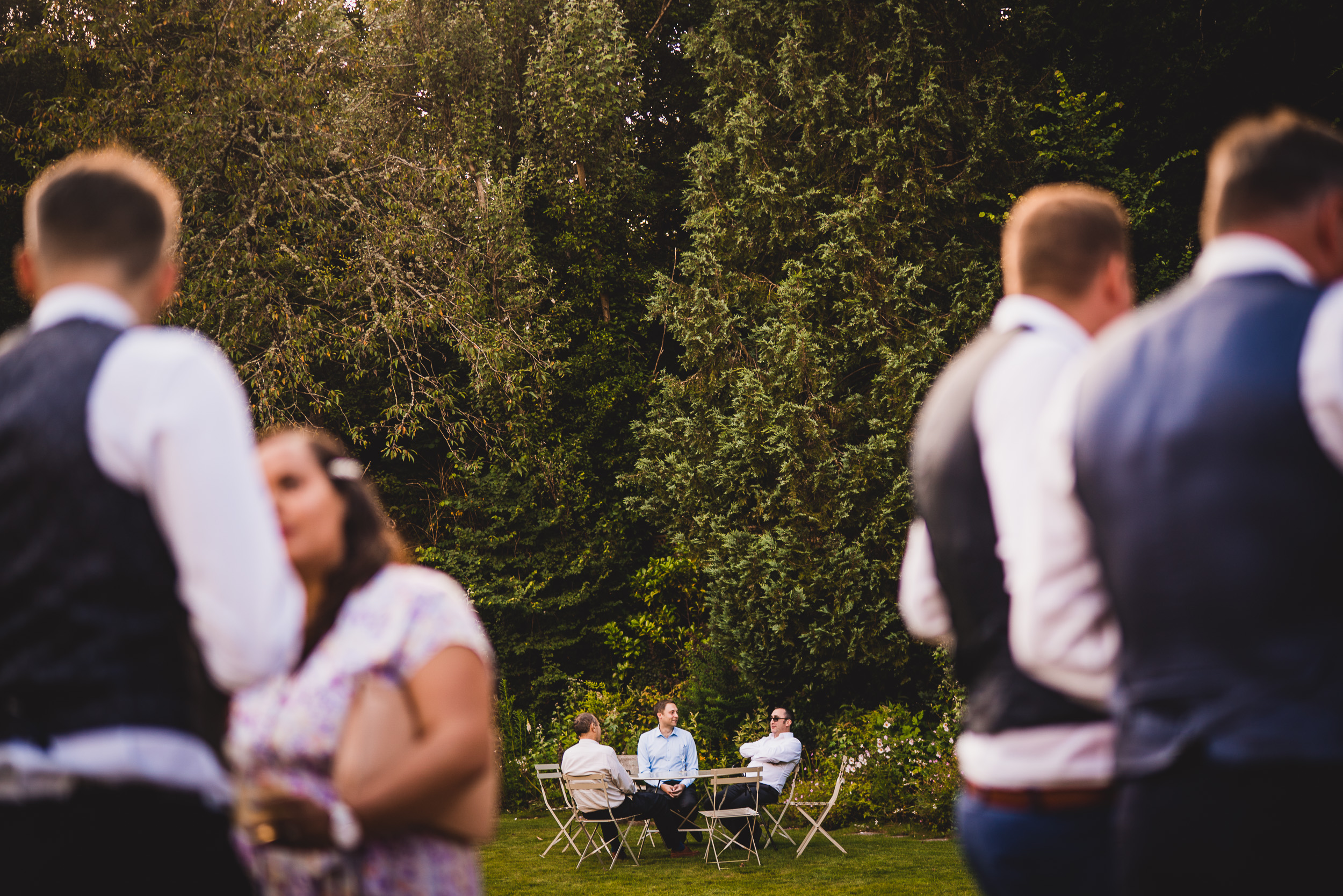 A wedding party posing for a photo in a garden.