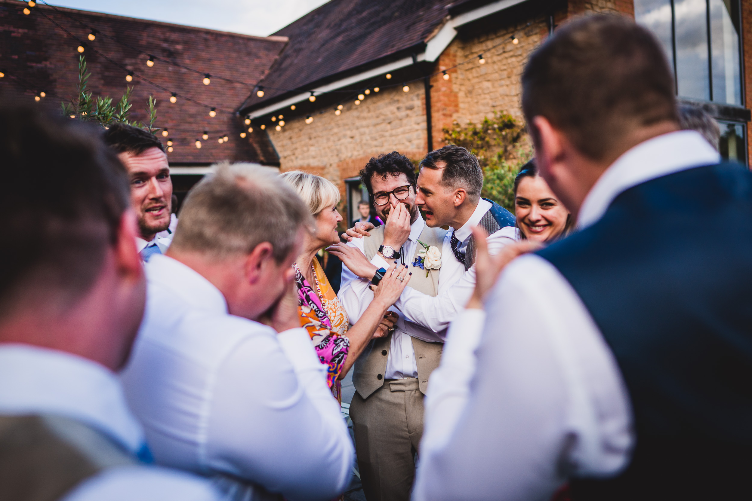 A group of people laughing in a wedding photo.