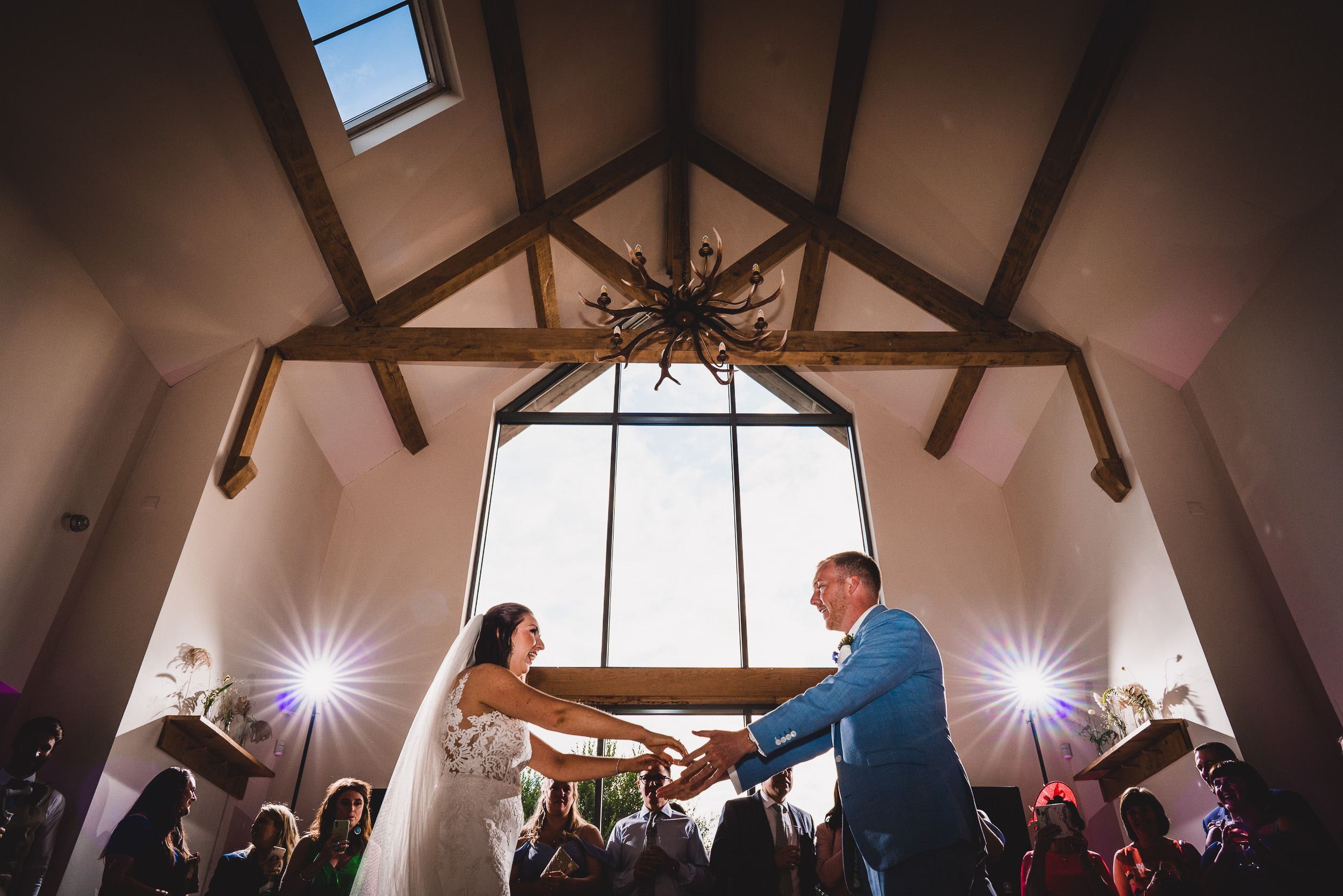 A wedding photographer captures the bride and groom's first dance in a rustic barn.