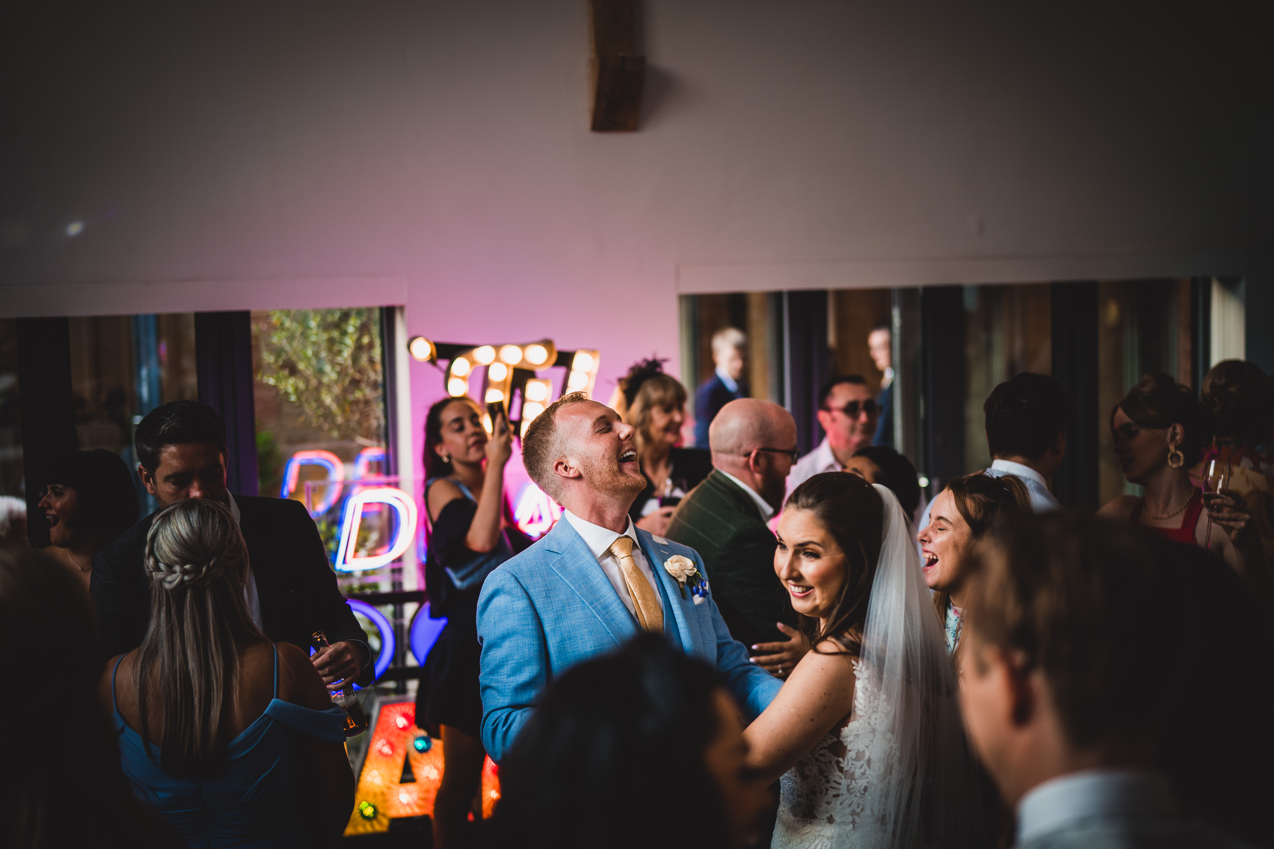 A wedding photographer captures the bride and groom dancing at their reception.