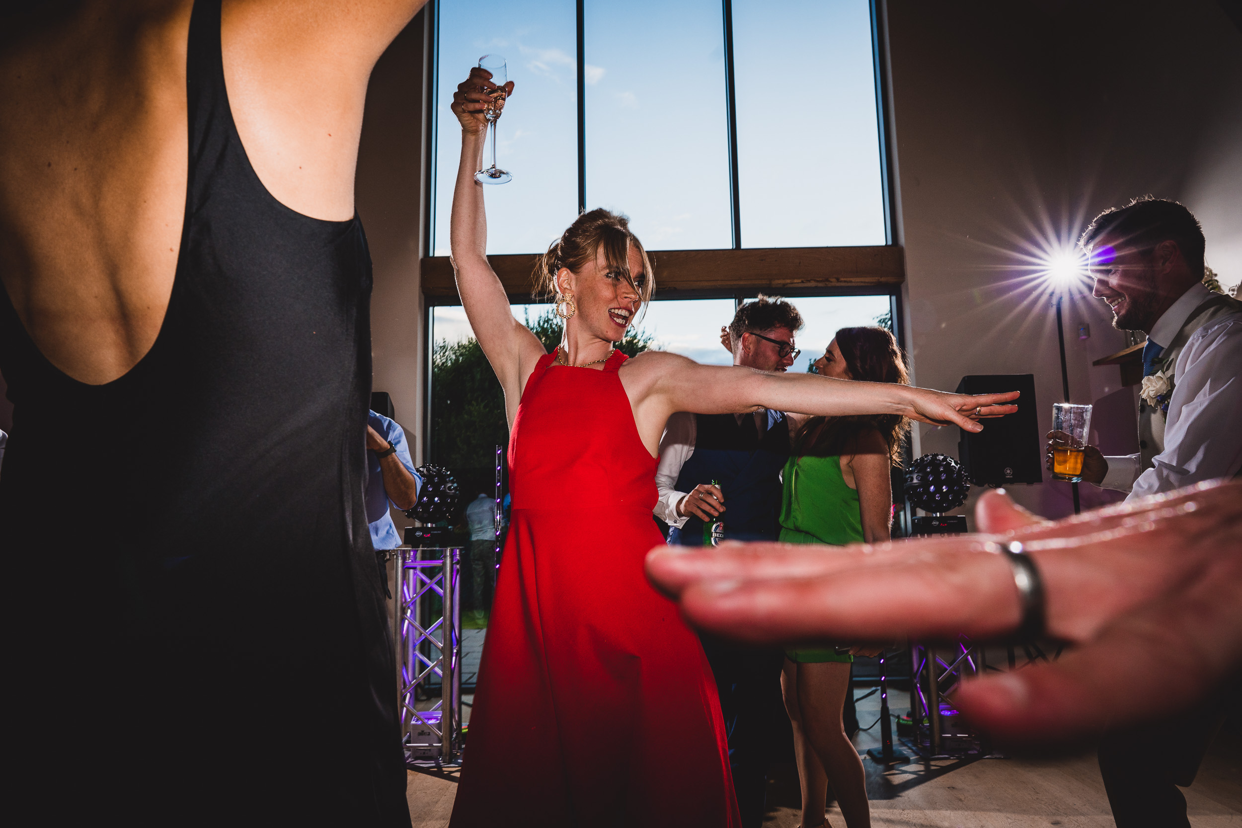 A woman in a red dress dancing at a wedding.