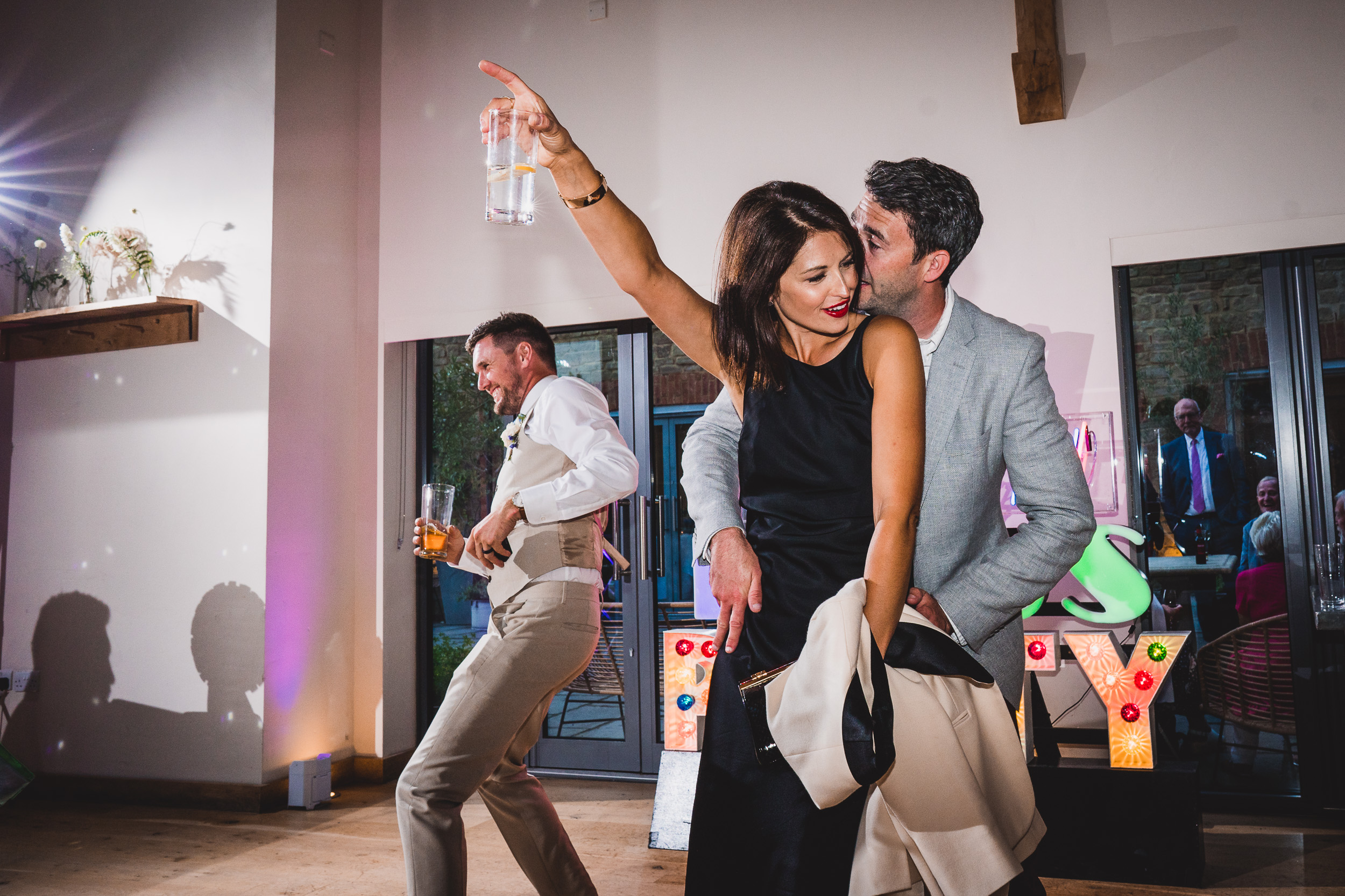 A bride and groom dancing at their wedding reception while being photographed.