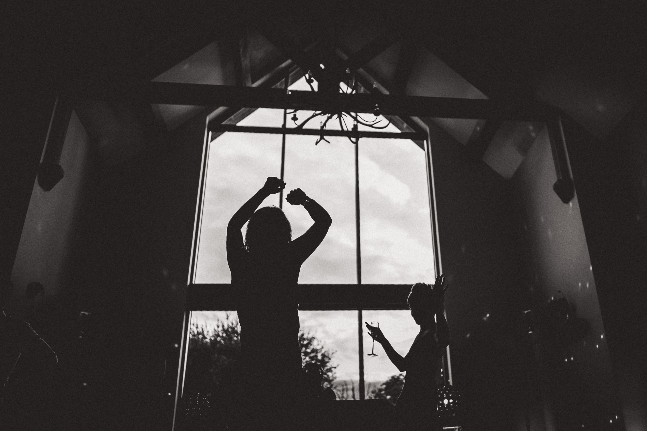 A bride dancing in front of a window, captured by a wedding photographer.