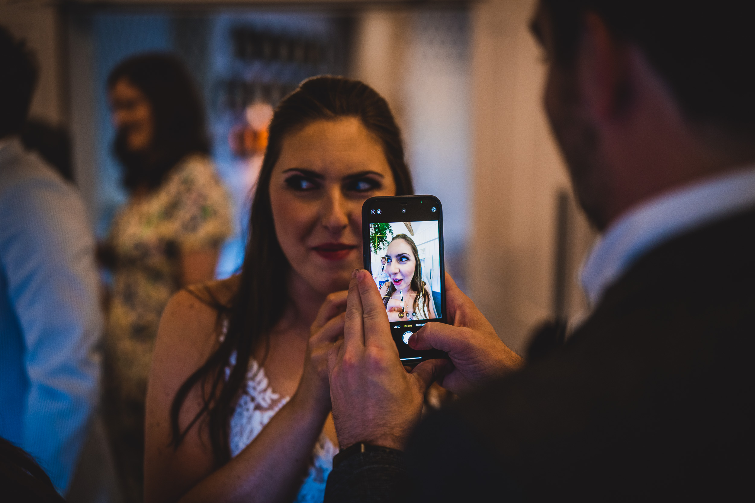 The groom capturing a selfie with his bride during their wedding celebration.