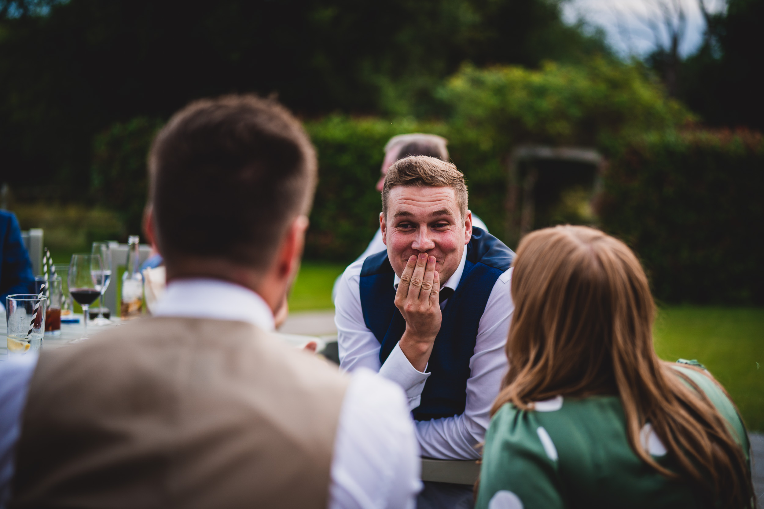 A groom laughing at his wedding reception.