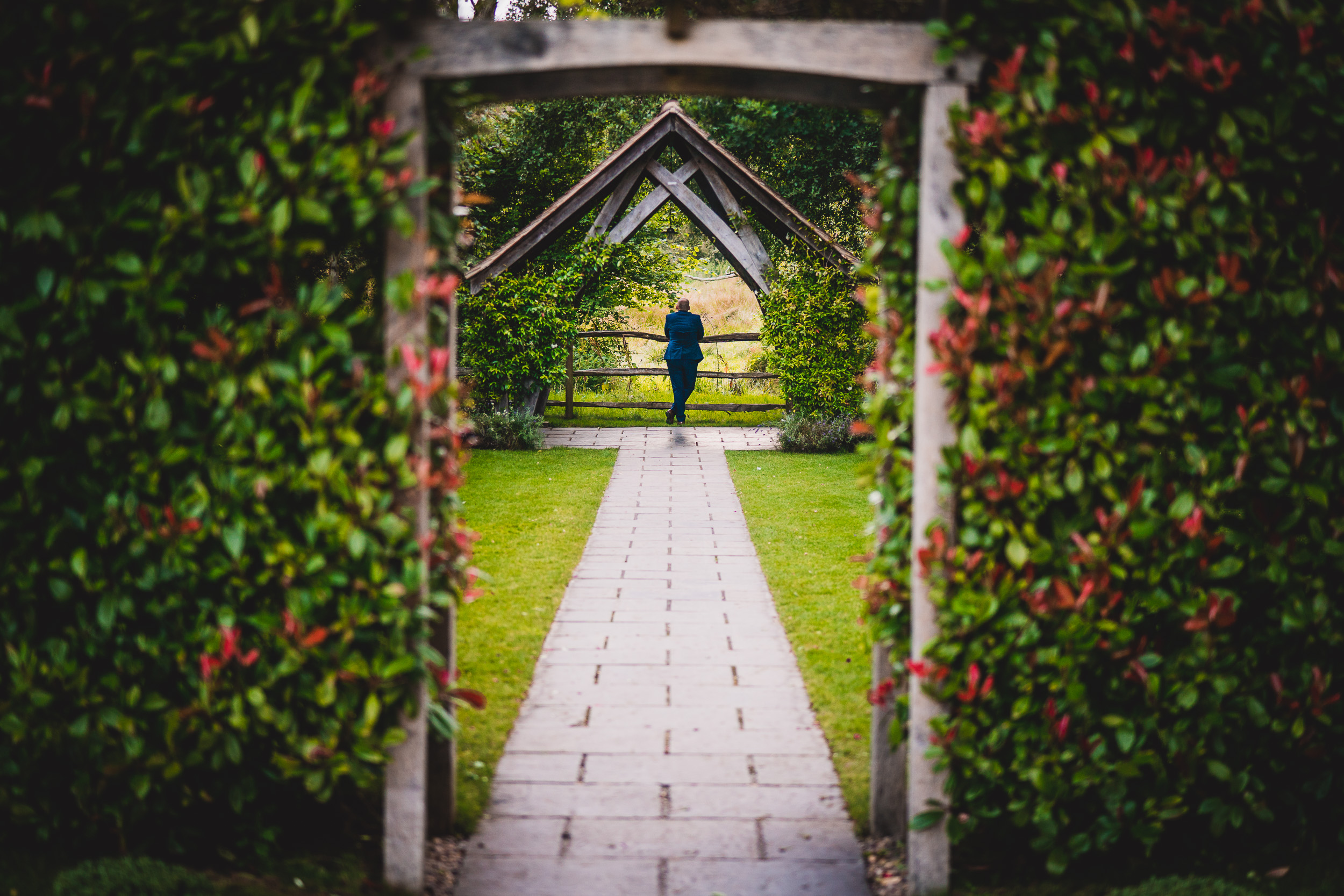 A couple posing for a wedding photo in a garden.