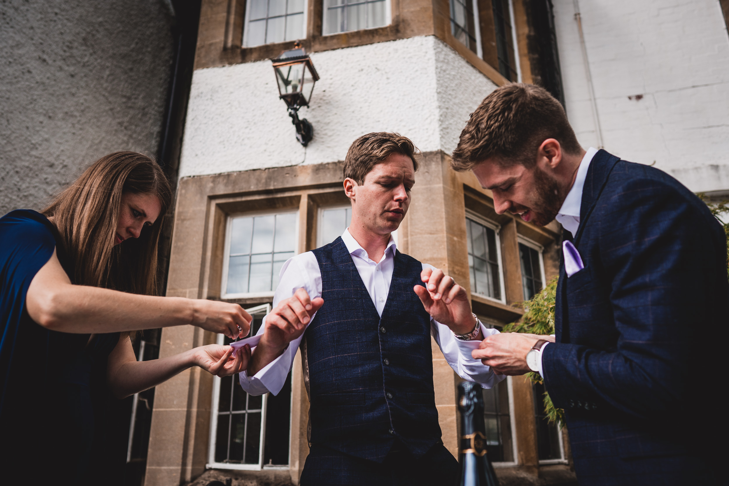 A group of men in suits are putting their rings on during a wedding ceremony.