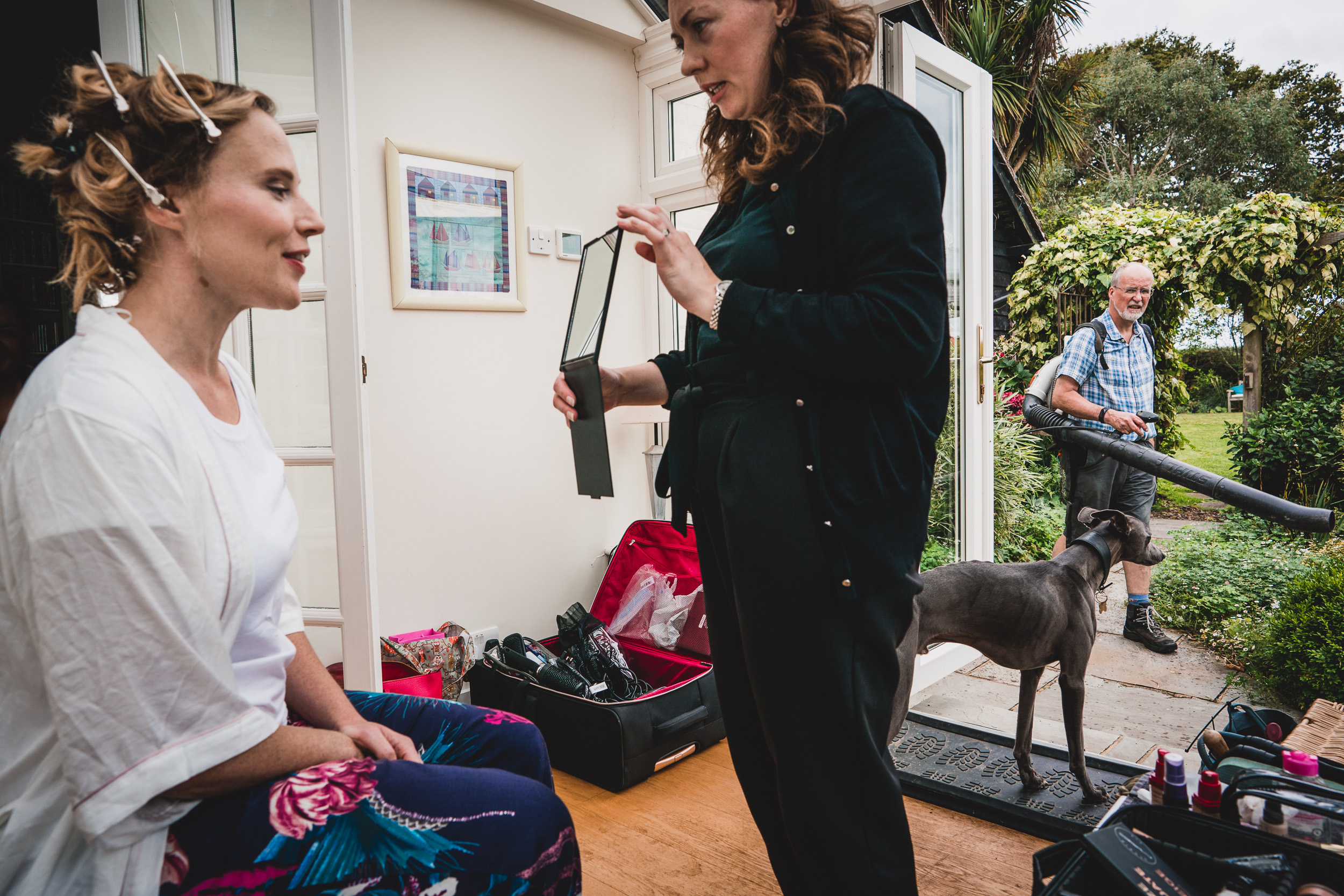 A bride getting her hair done in front of a wedding photo.