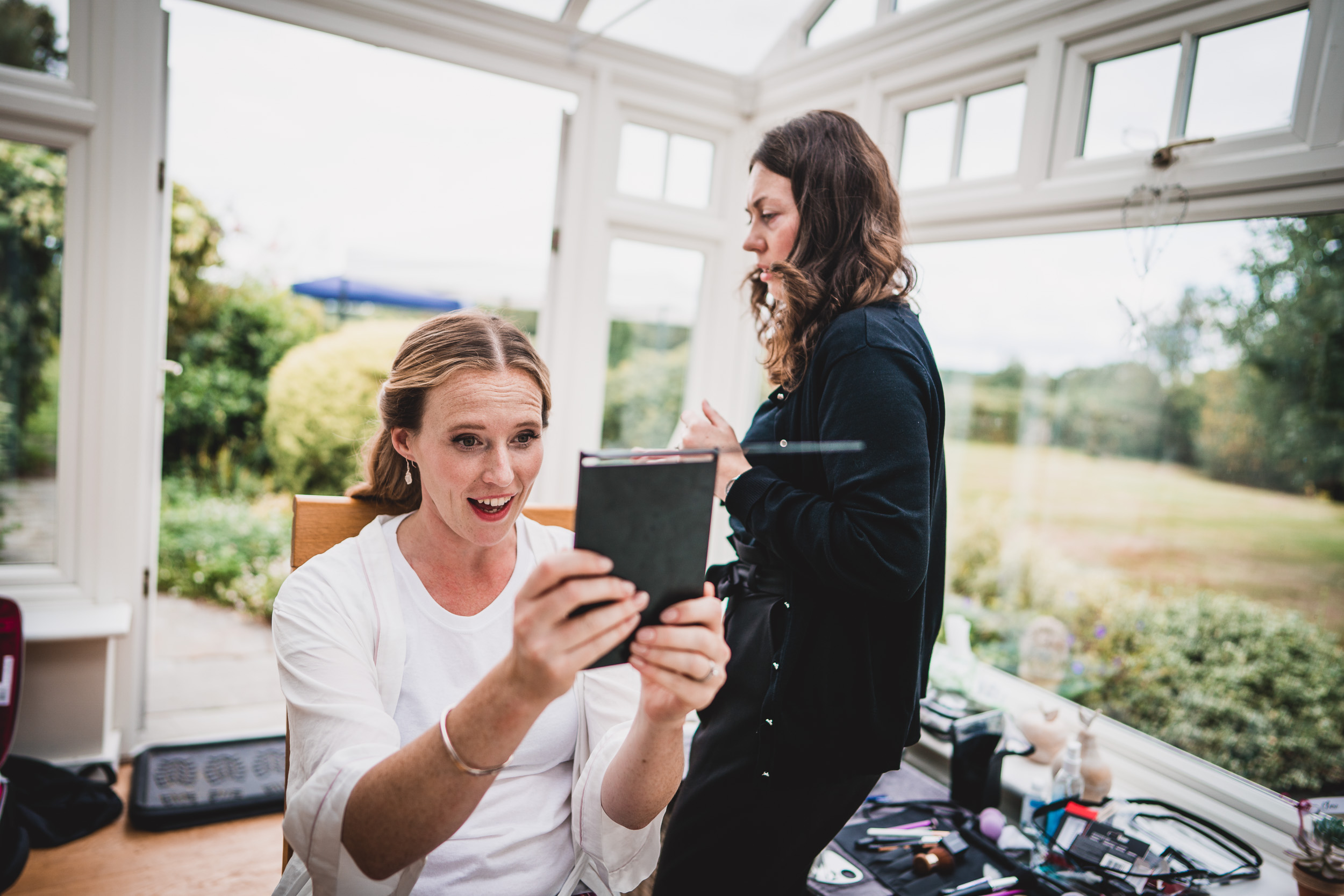 A woman preparing for her big day by checking her phone before getting married.