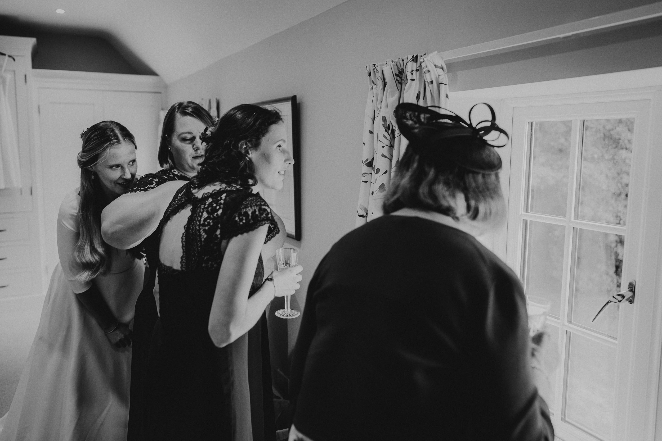 Black and white wedding photo of bridesmaids getting ready.