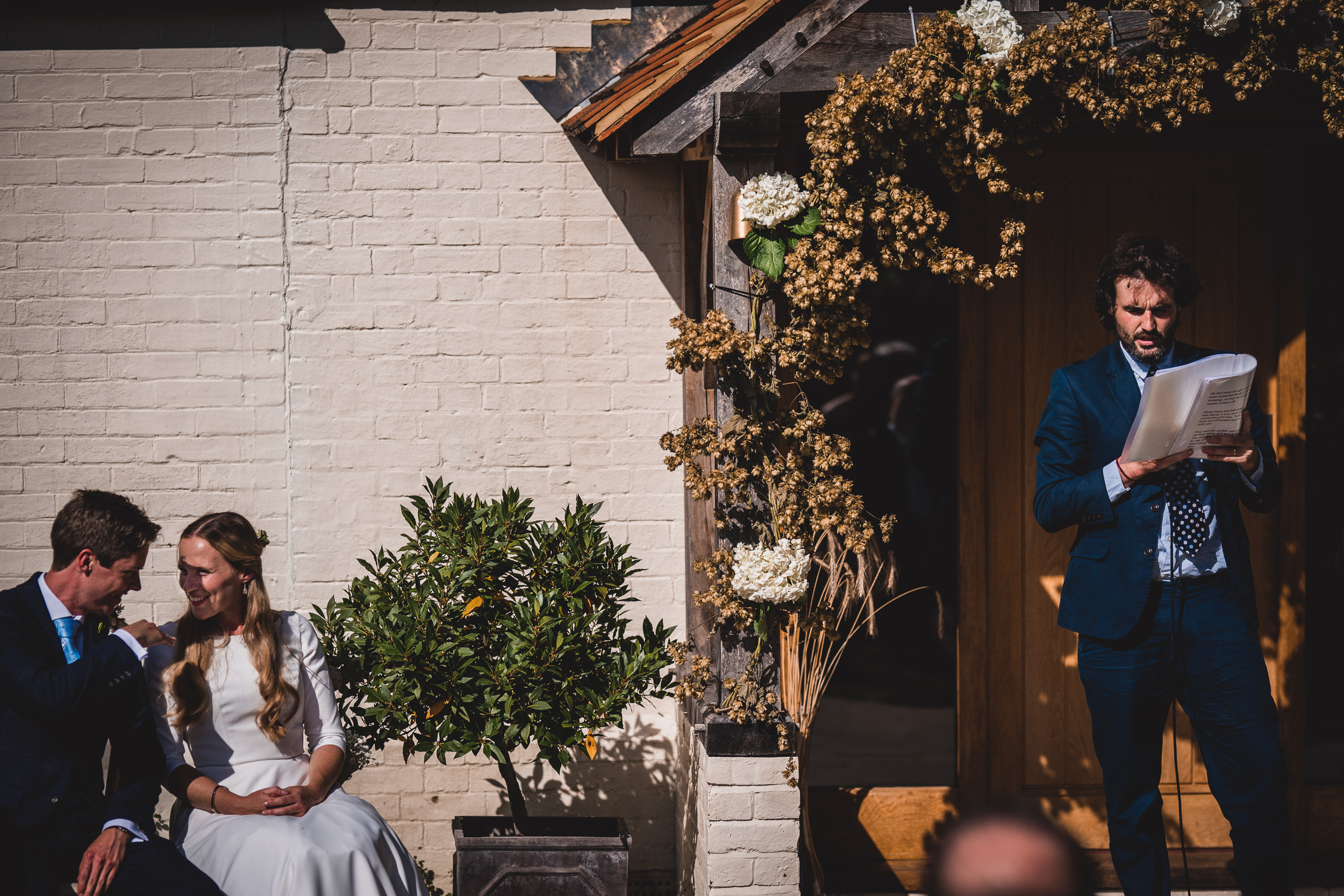 A bride and groom exchanging vows during their wedding ceremony in front of a house - a heartfelt wedding photo.