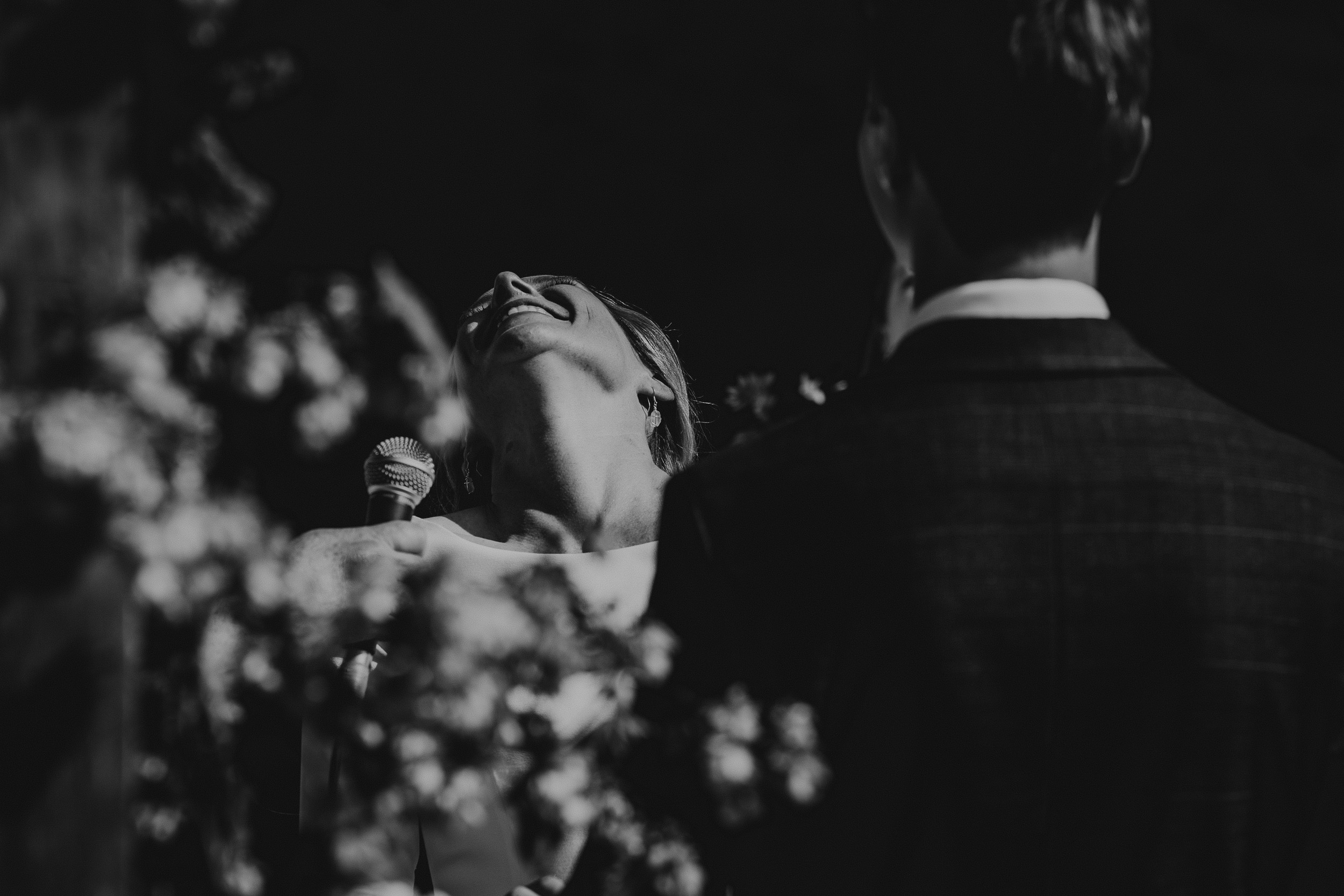 A black and white wedding photo capturing the groom and bride's gaze.