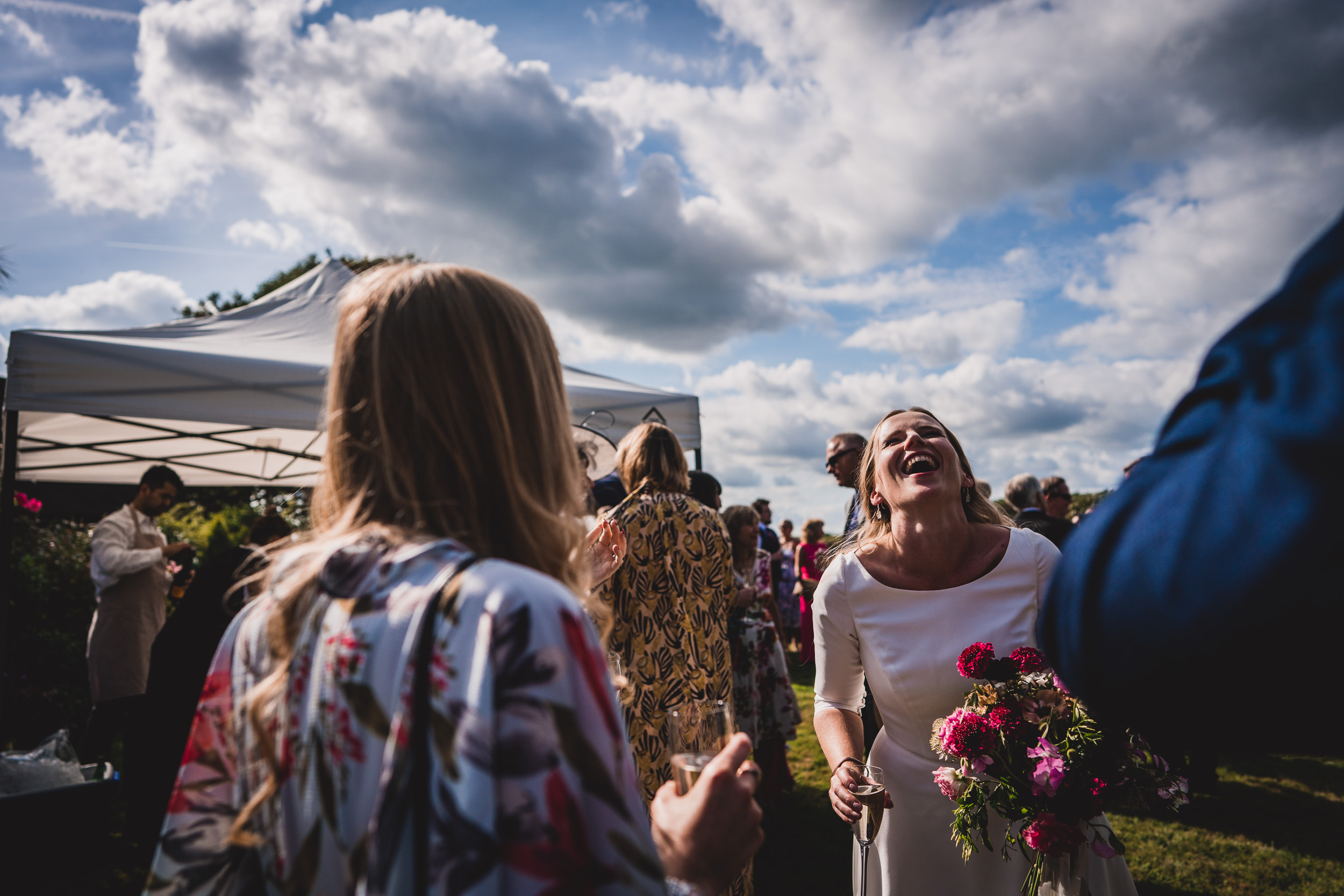 A newlywed couple sharing laughter at their wedding captured by the photographer.