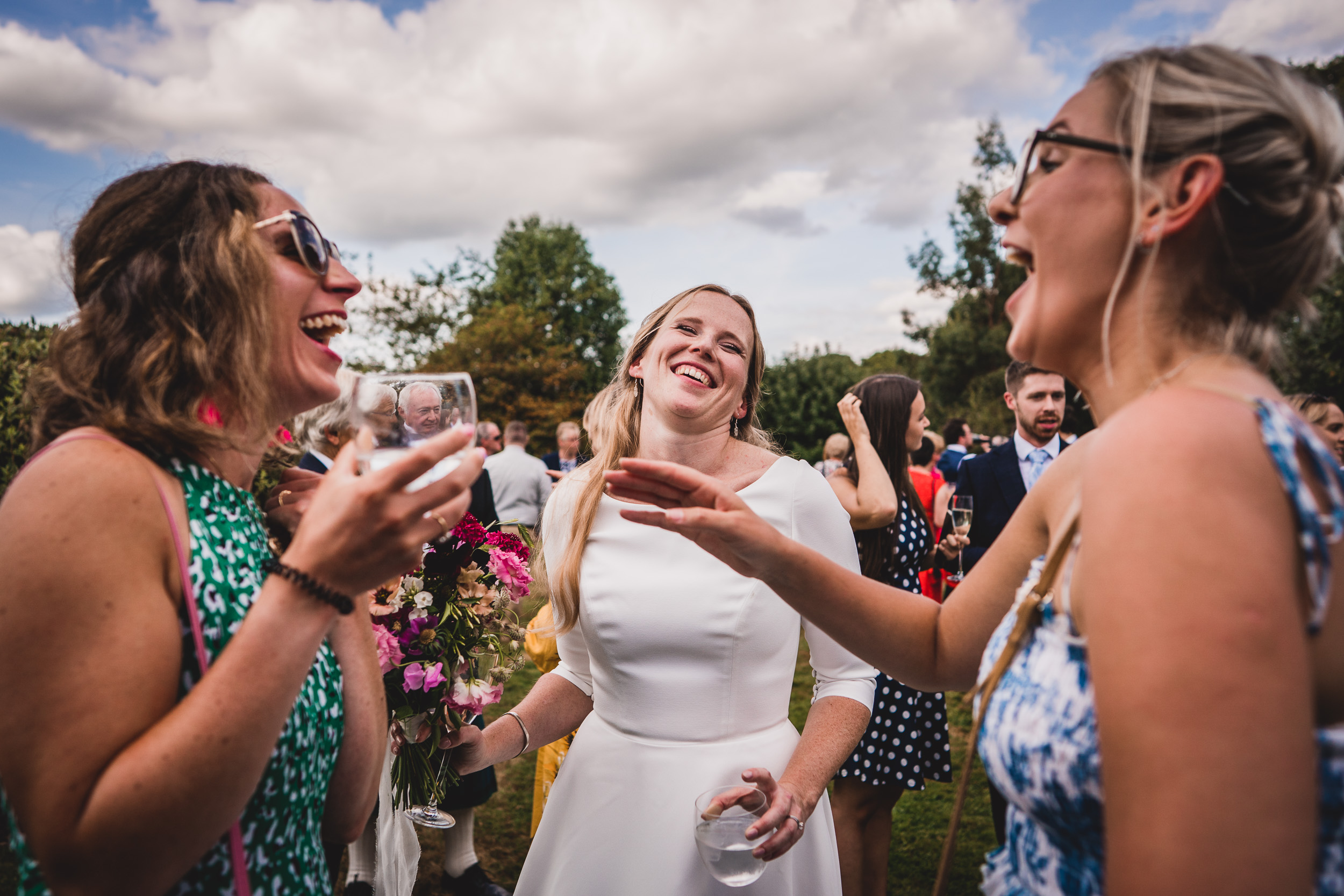 A wedding photo capturing bridesmaids gleefully laughing.