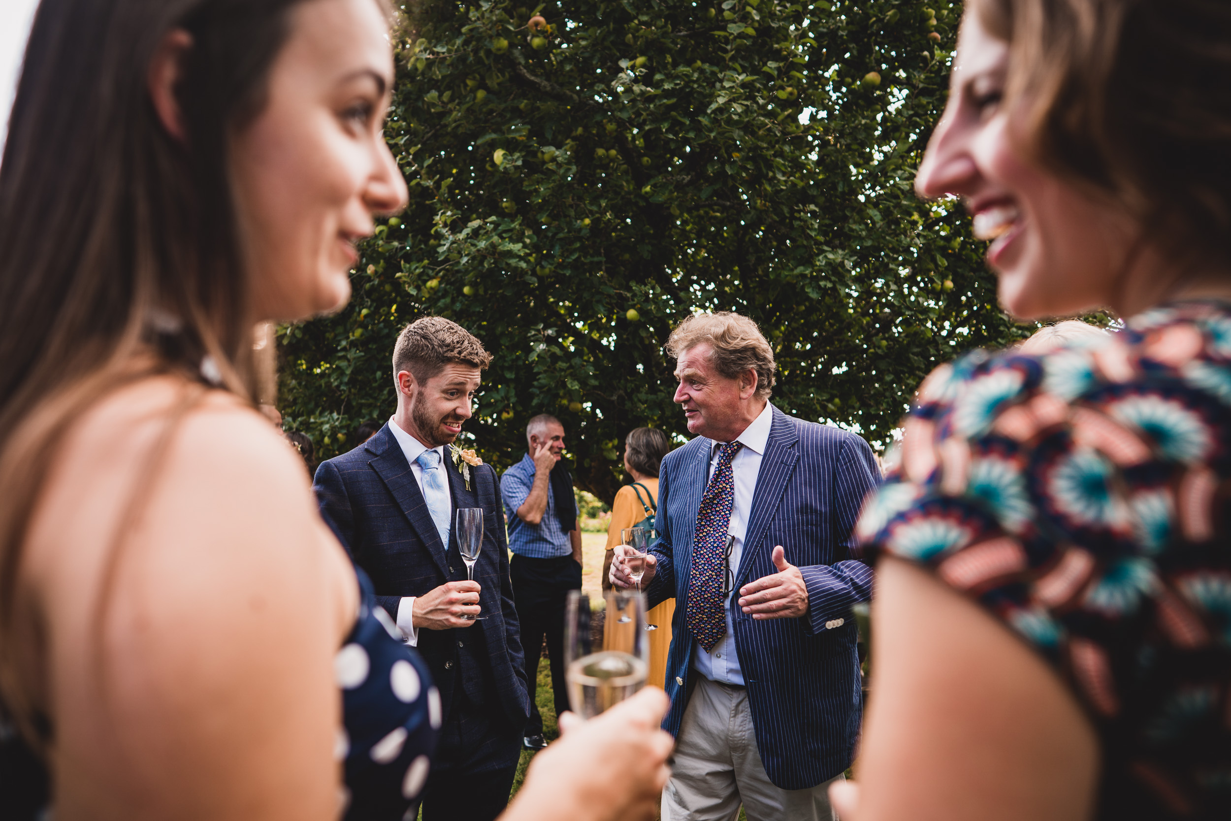 A groom and his guests enjoying wine at a wedding party.