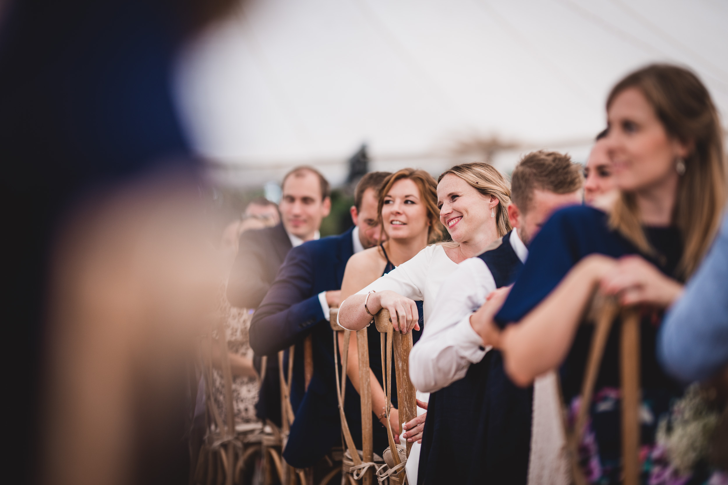 A group of brides and grooms captured by a wedding photographer in a tent for a stunning wedding photo.